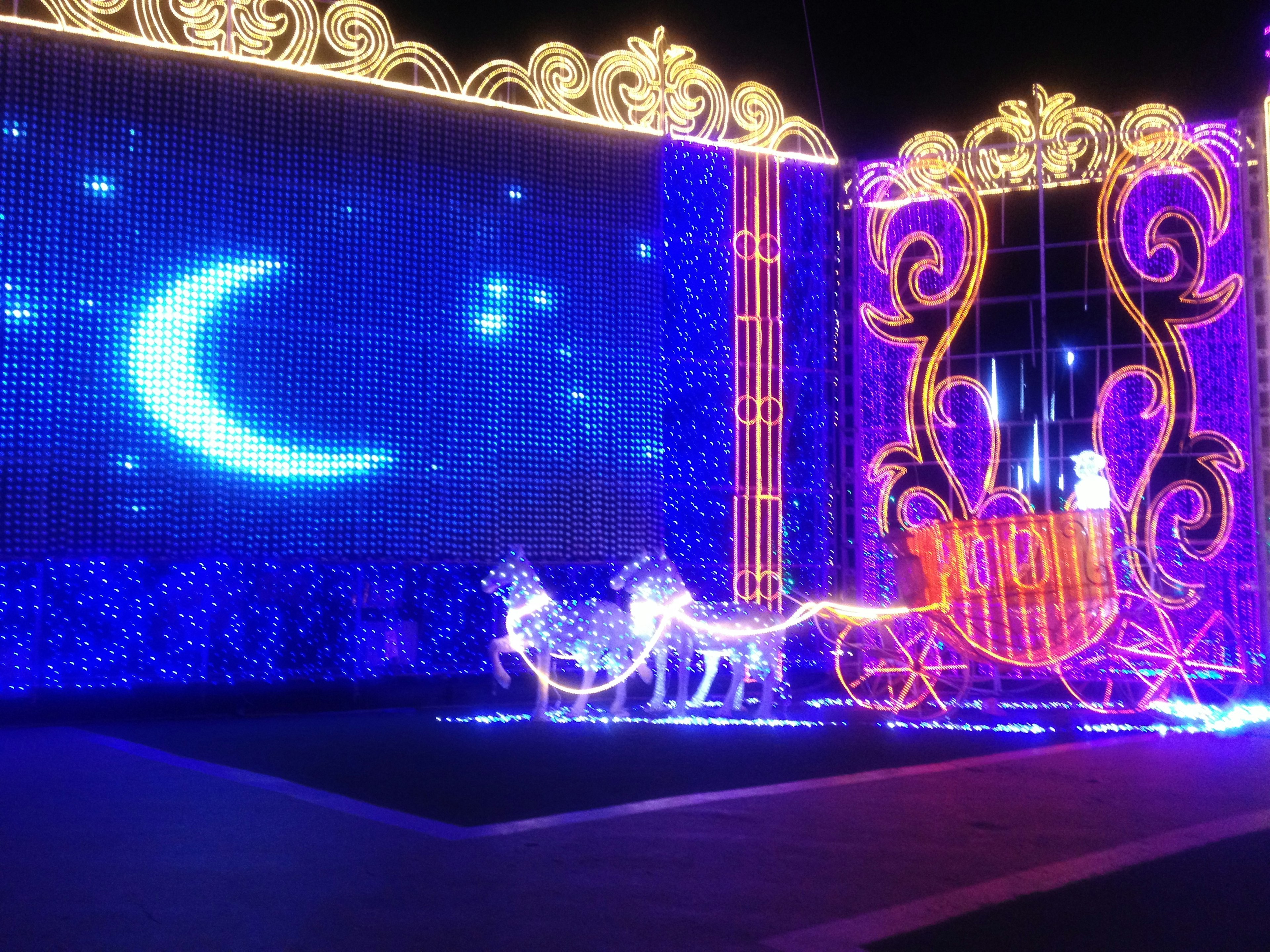 Carruaje iluminado con un fondo de luna azul en una exhibición nocturna festiva