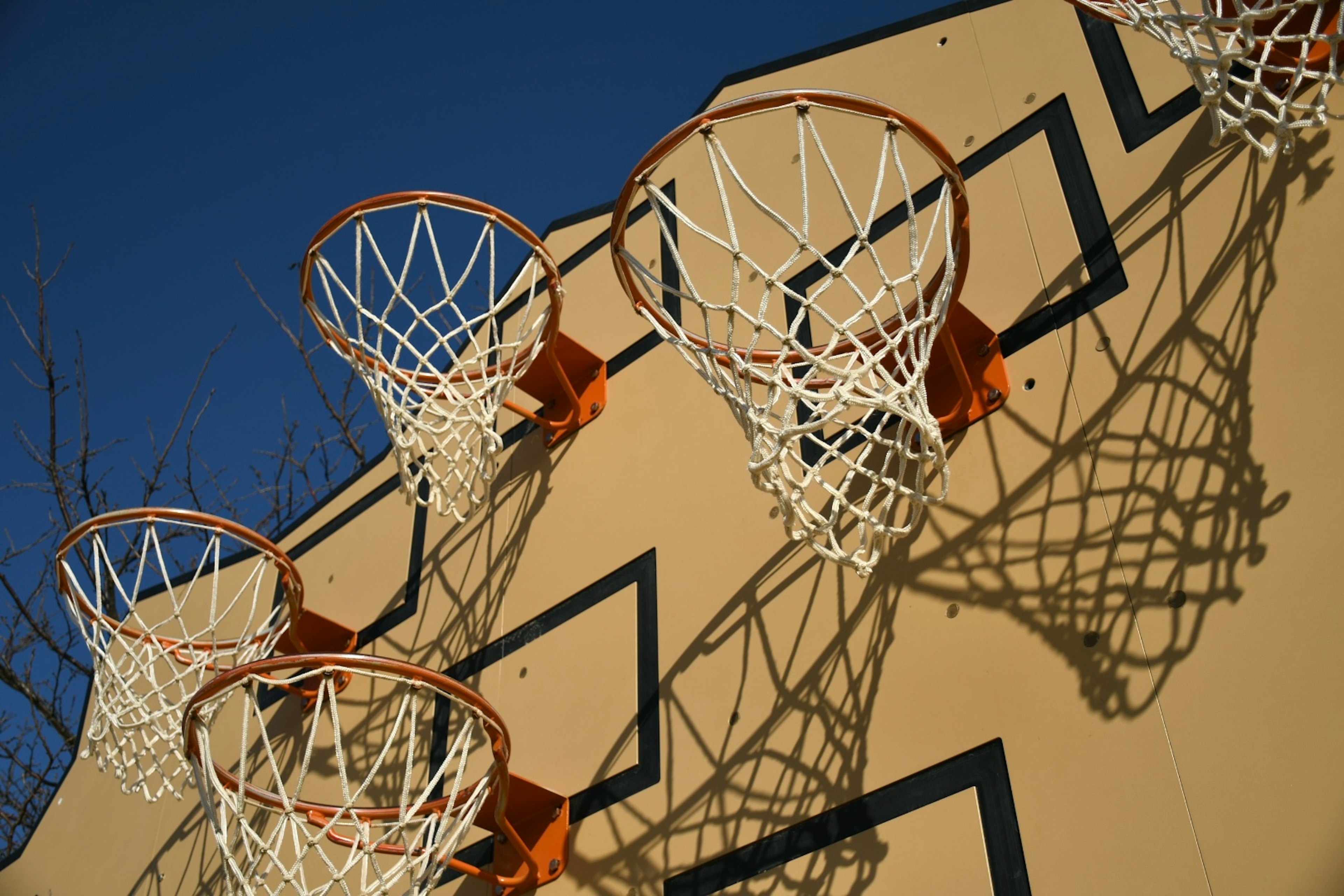 Imagen de aros de baloncesto montados en una pared Múltiples aros y sus sombras crean un efecto visual impresionante