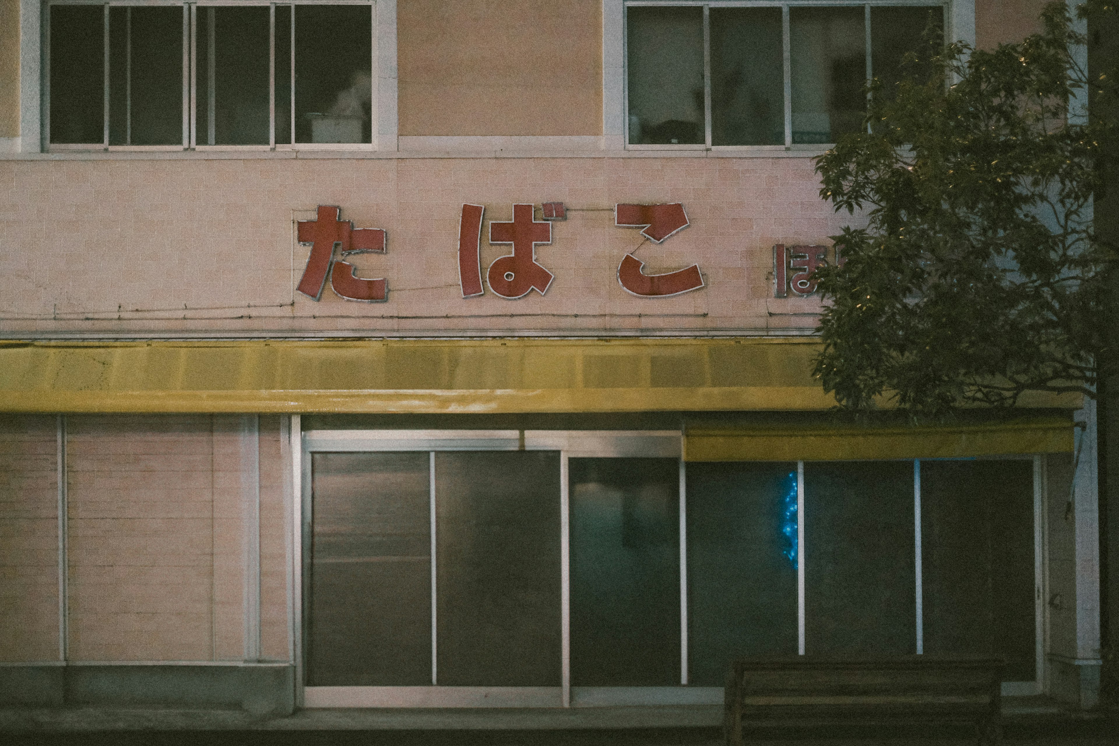 Exterior de una tienda de tabaco con toldo amarillo