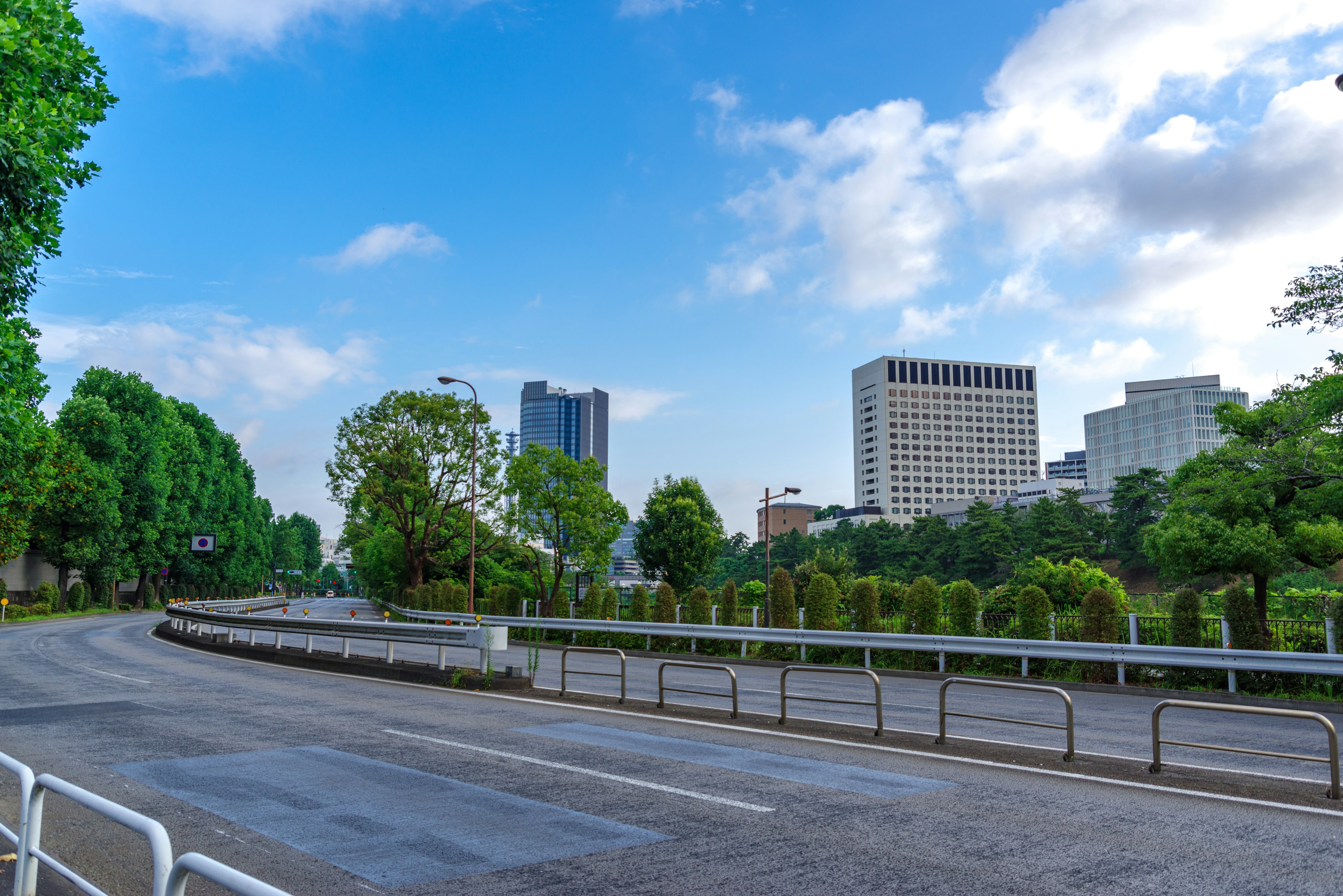 Cityscape under blue sky with green trees