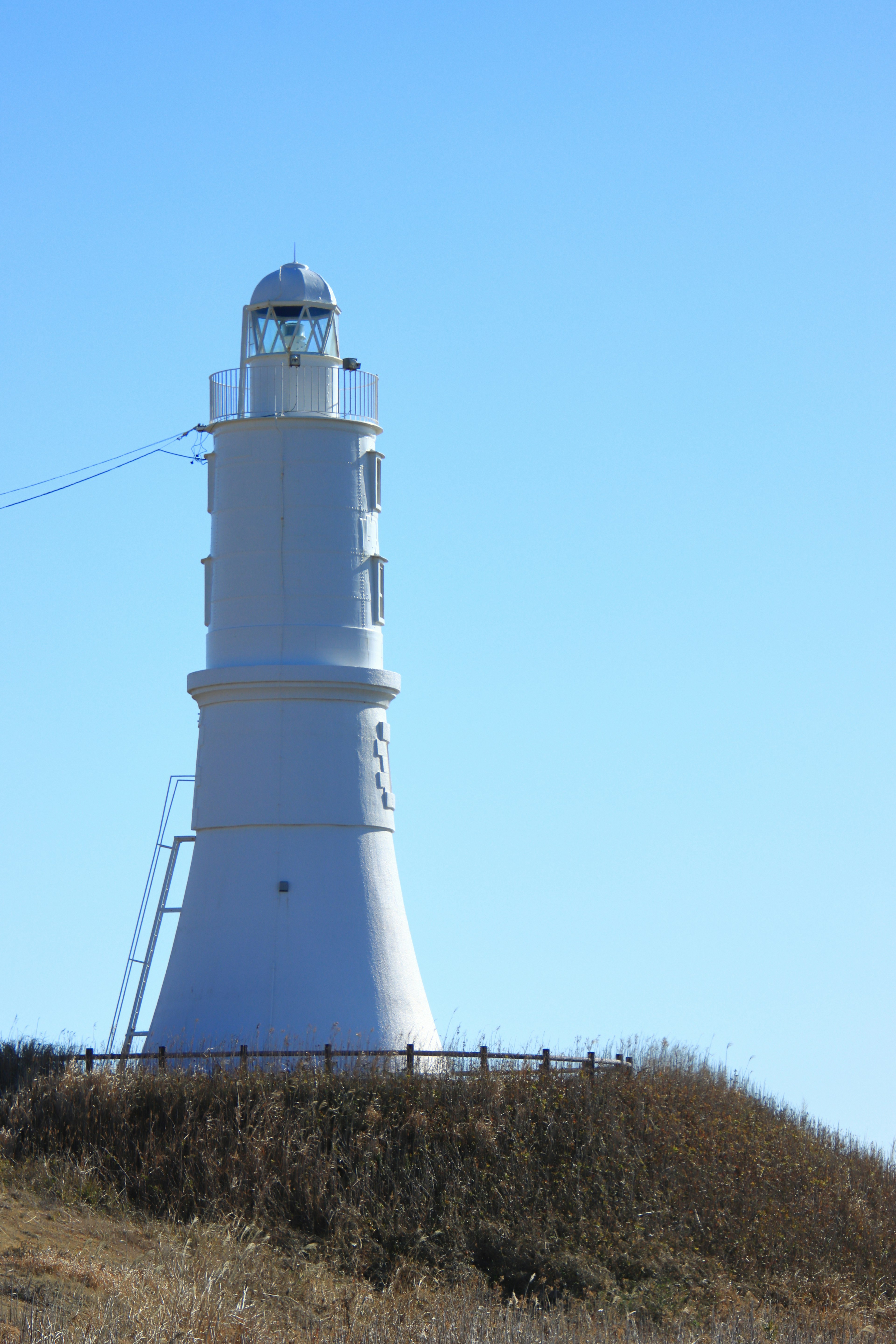 Un faro bianco che si erge sotto un cielo blu