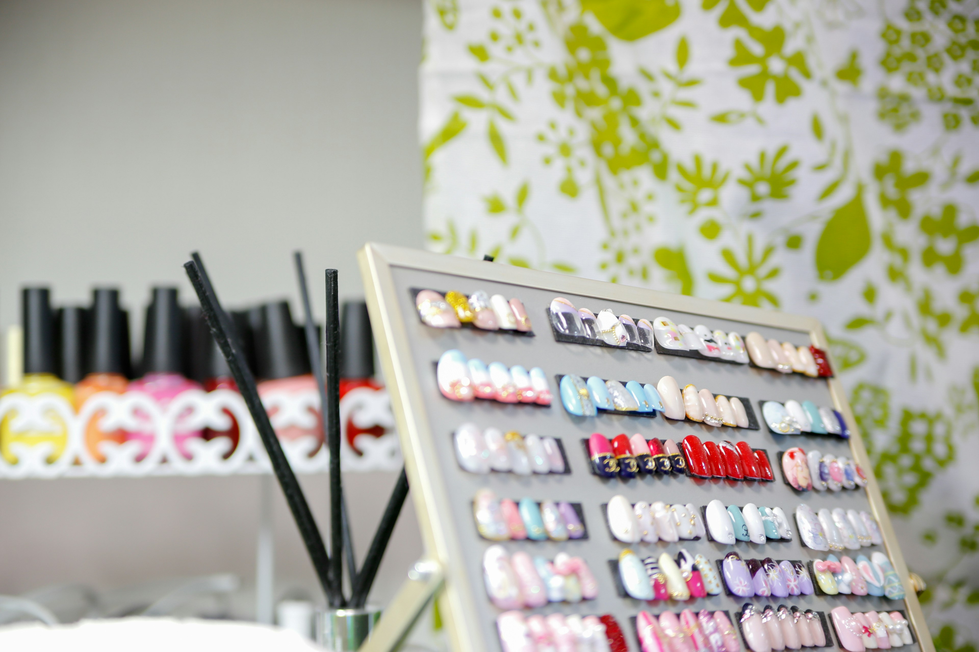 Colorful nail tips display in a nail salon with polish bottles