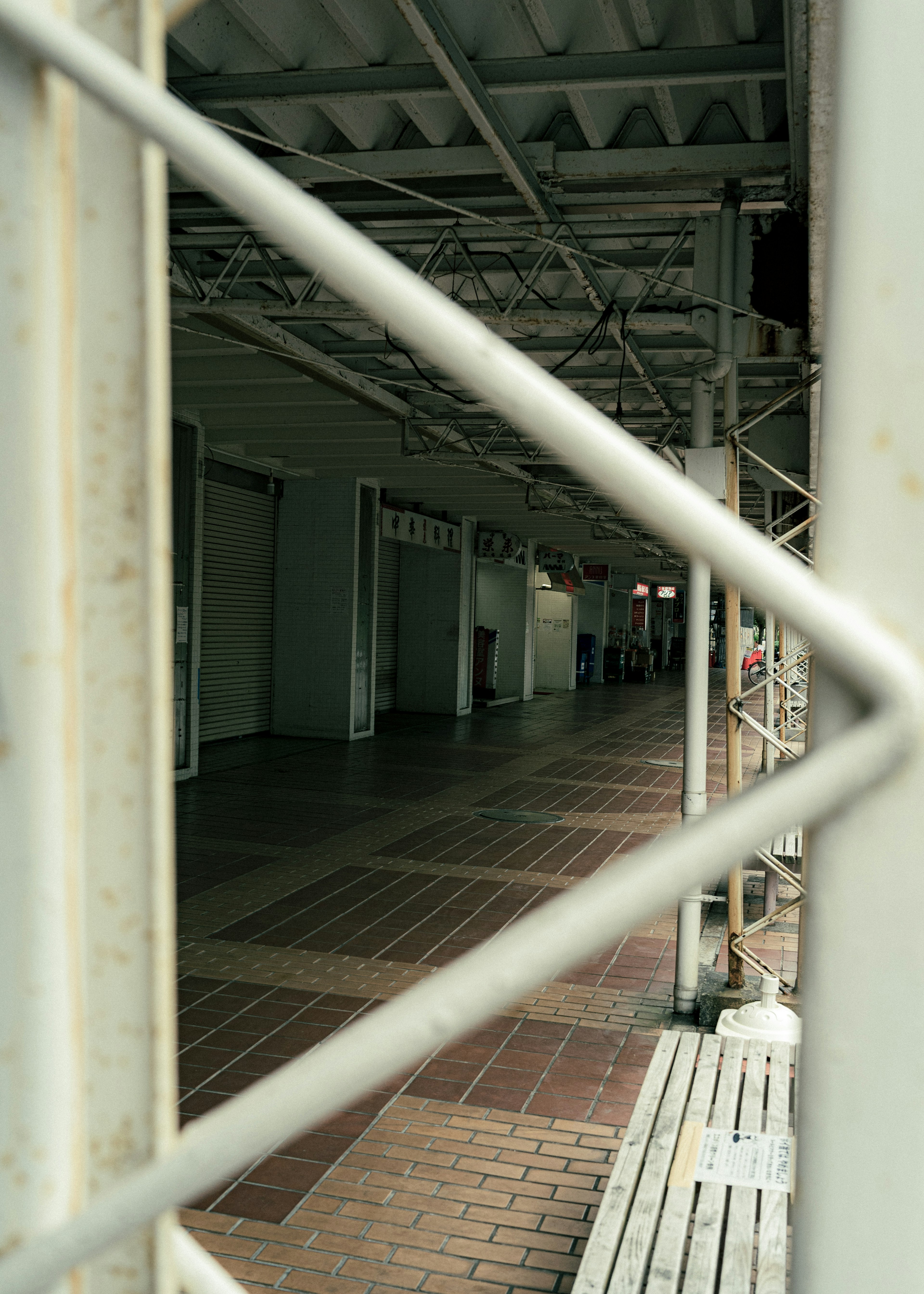 Vista de un corredor comercial a través de una cerca de rejilla