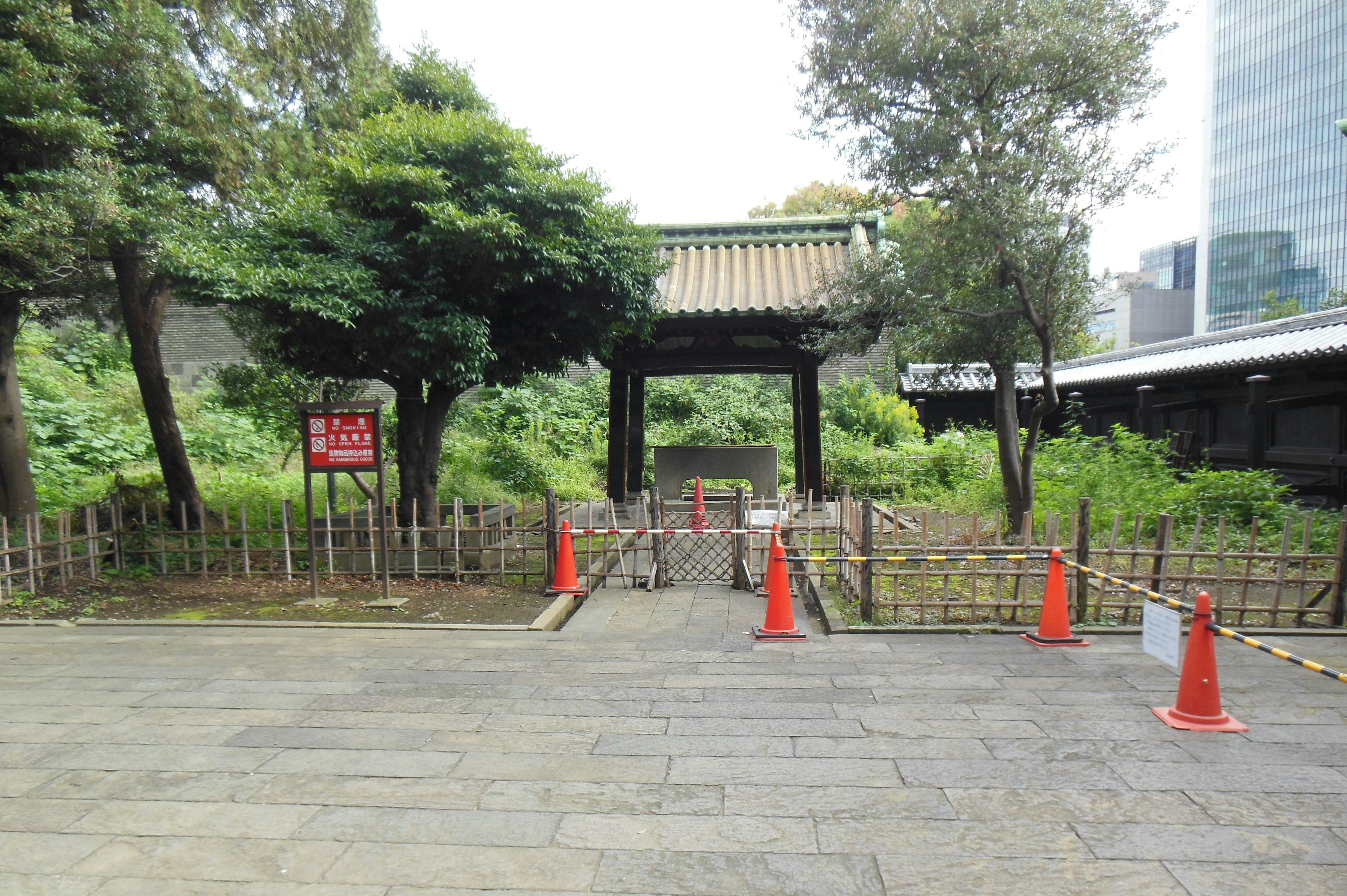 Porte traditionnelle entourée de verdure avec des panneaux d'avertissement