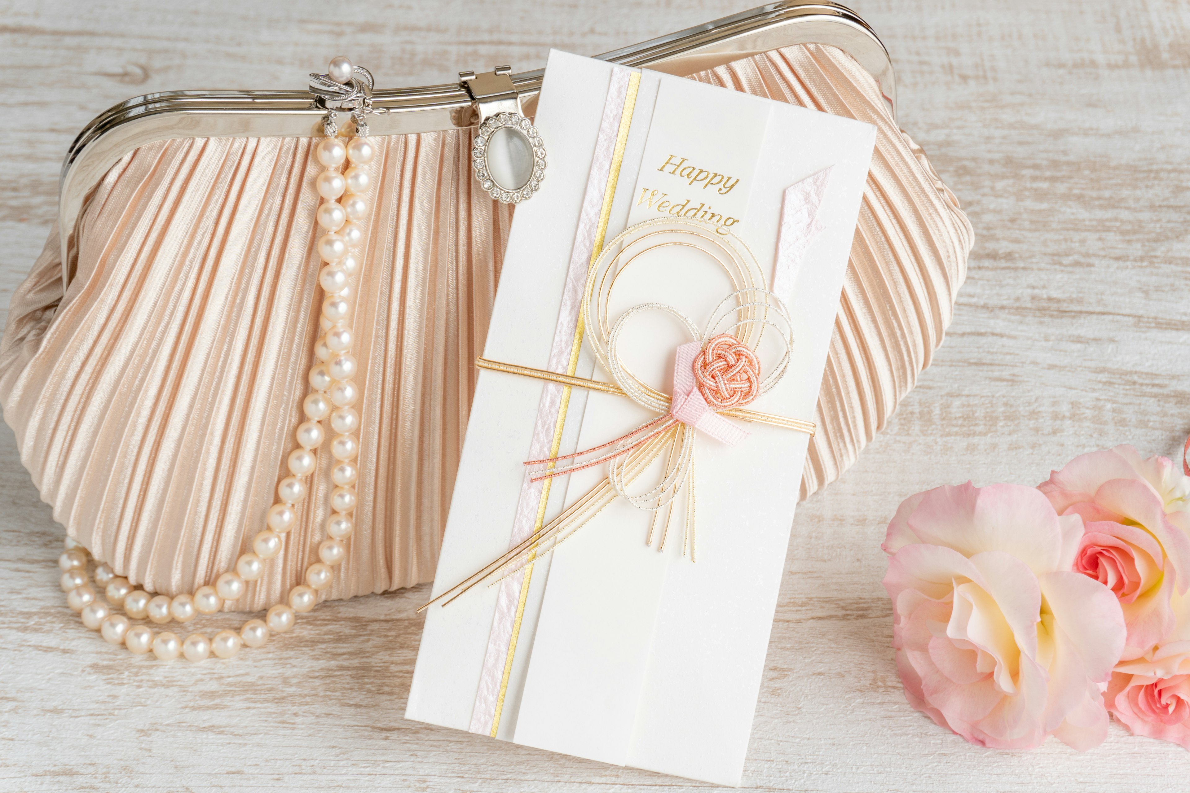 Image of a pink clutch bag with an embellished invitation card