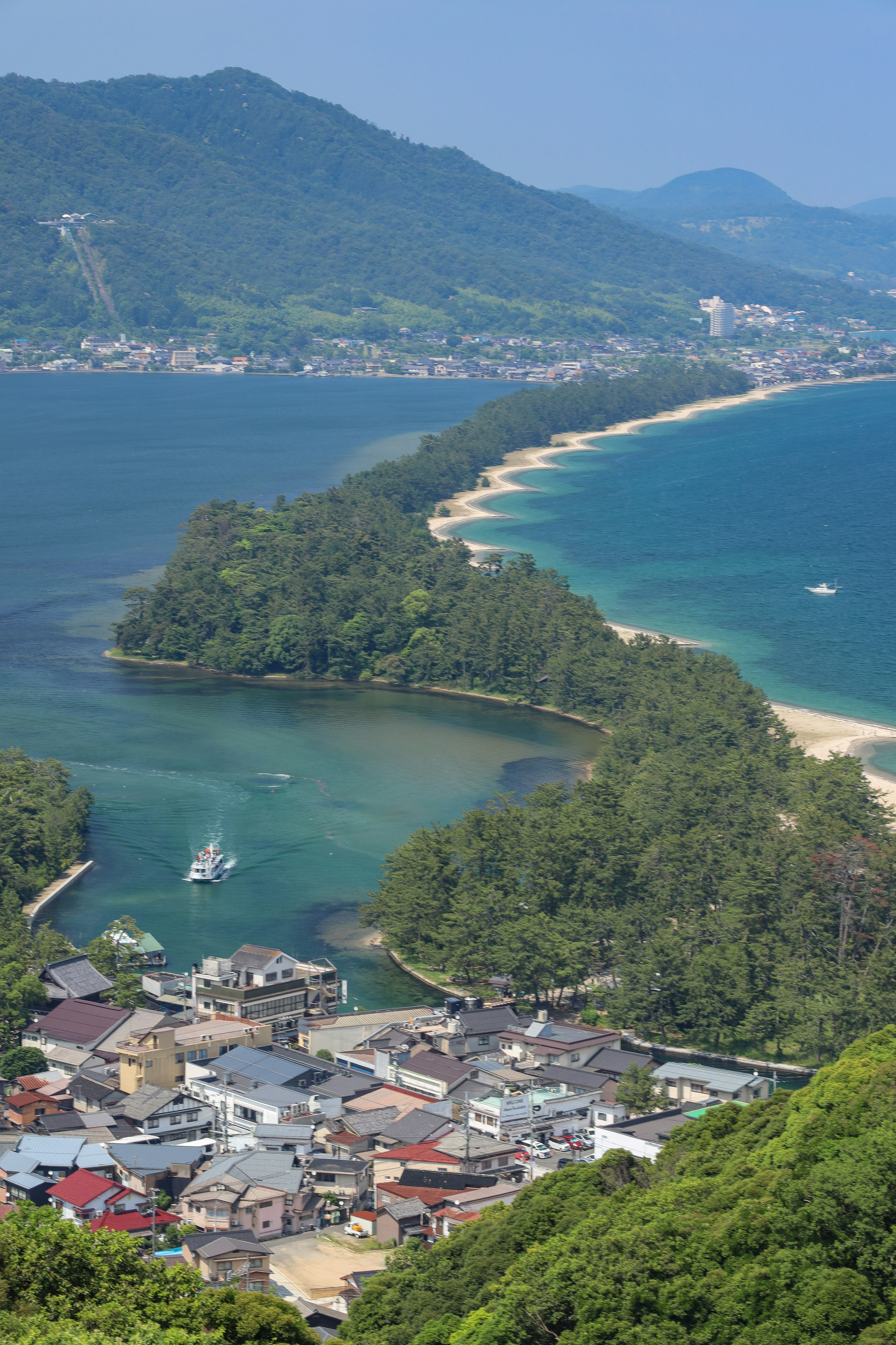 Vista panoramica di una città costiera con una costa tortuosa e vegetazione lussureggiante