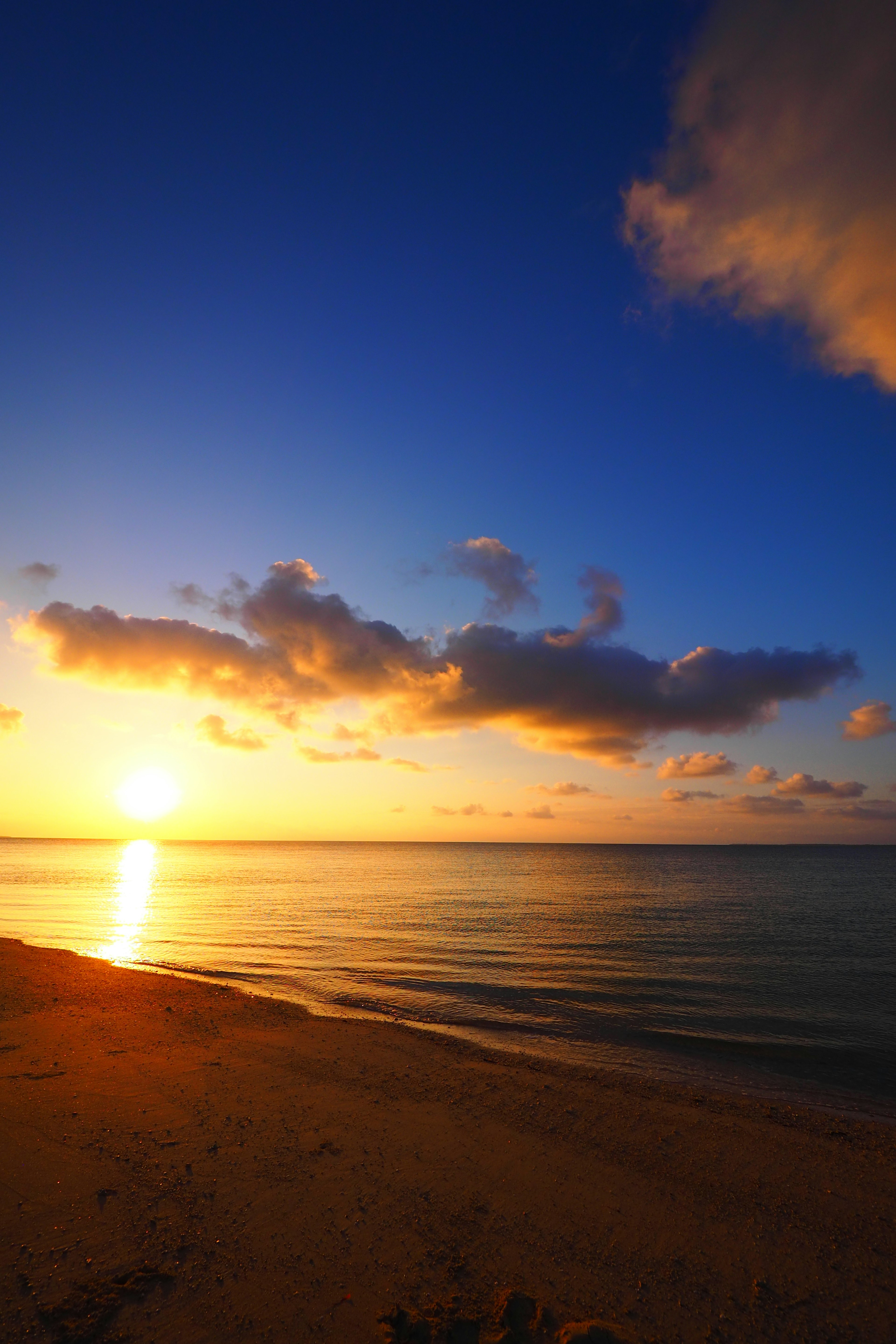 Bellissimo tramonto sopra l'oceano con cielo blu e nuvole arancioni