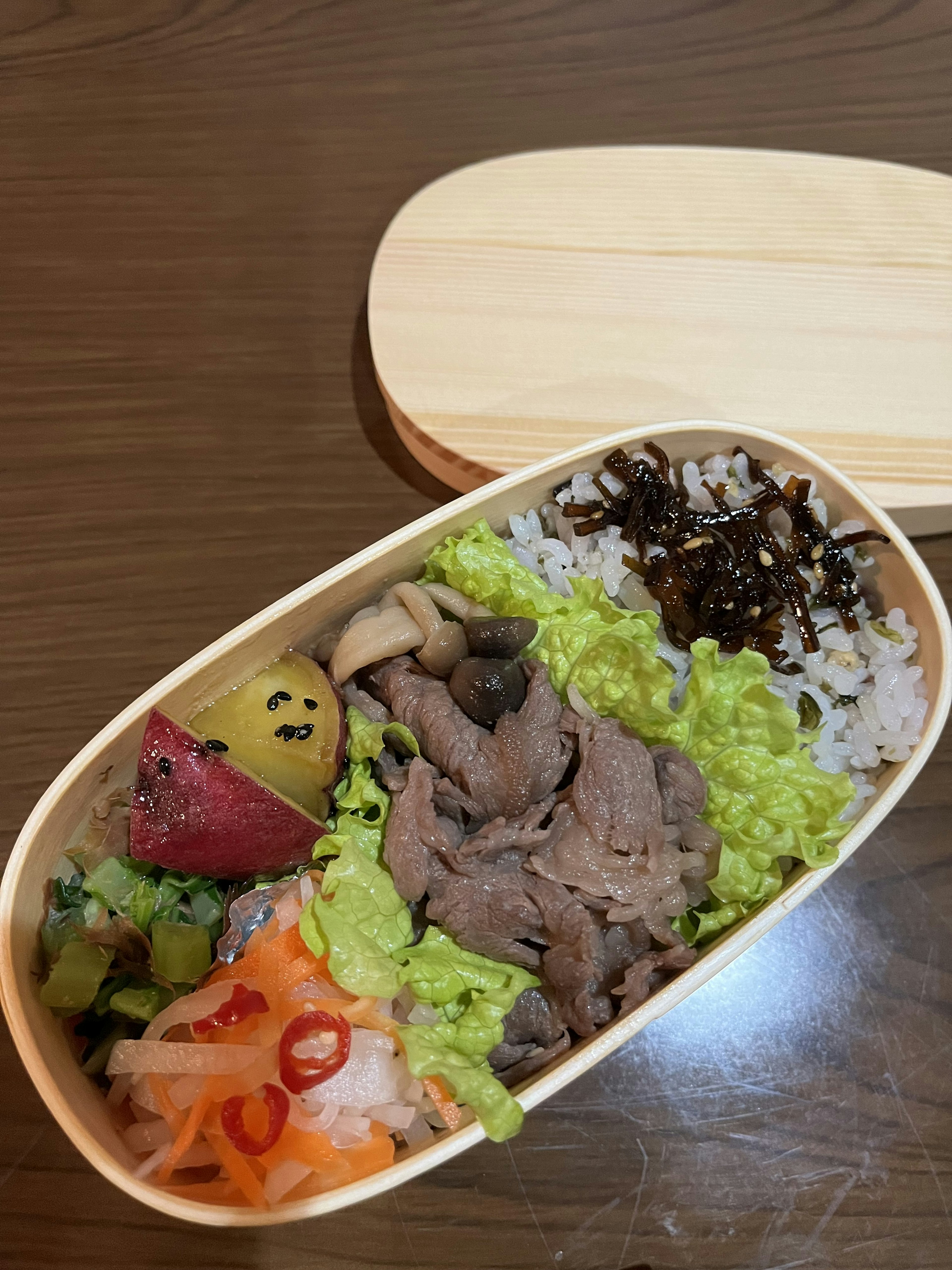 Hộp bento chứa cơm thịt rau và dưa chua với màu sắc rực rỡ