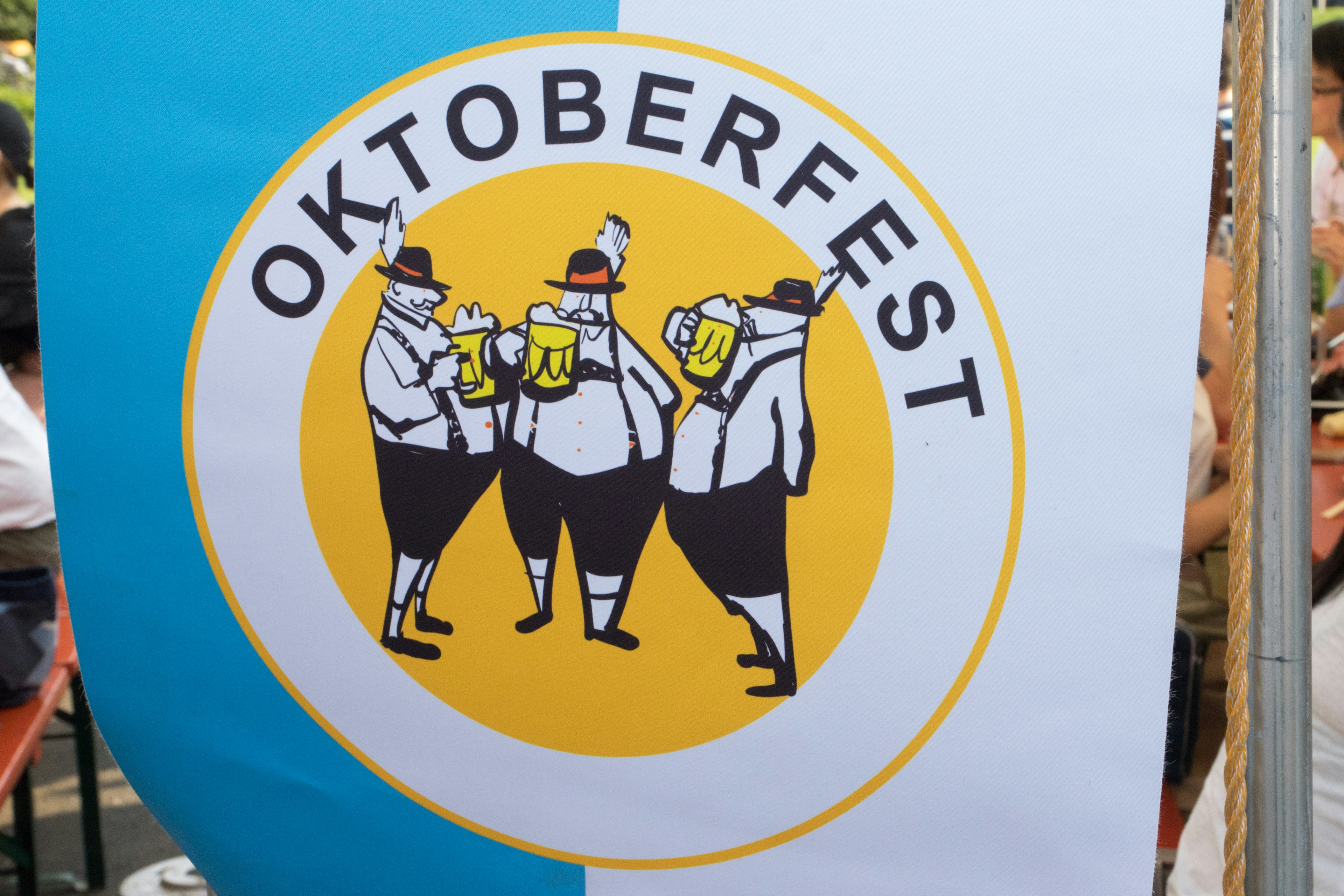 Oktoberfest logo on a flag featuring four men holding beers