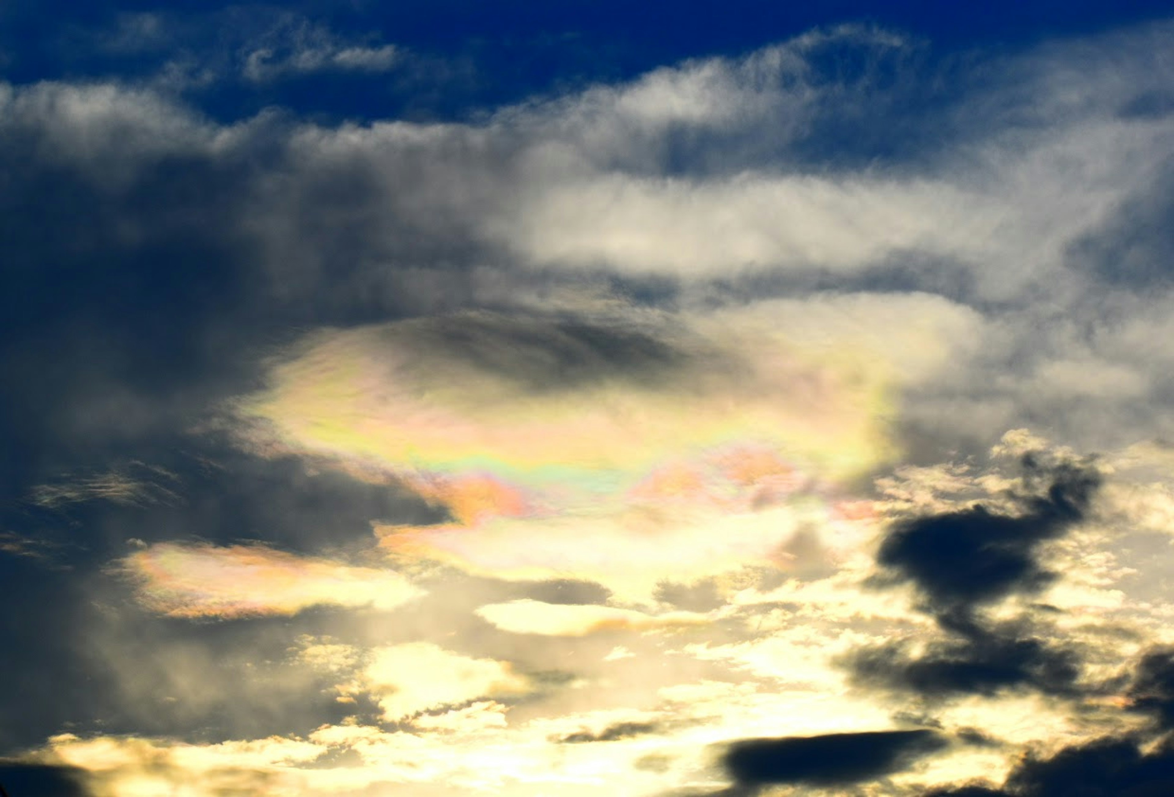 Una hermosa escena de luz iridiscente apareciendo en el cielo rodeado de nubes