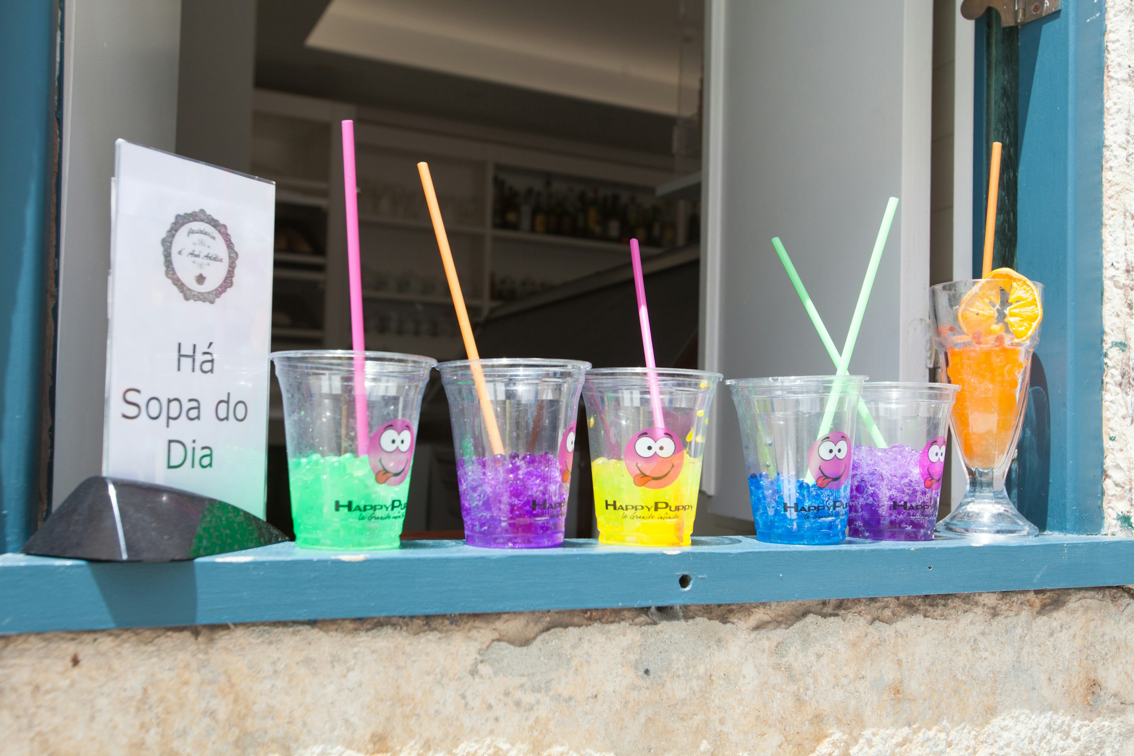 Bebidas coloridas exhibidas en un alféizar