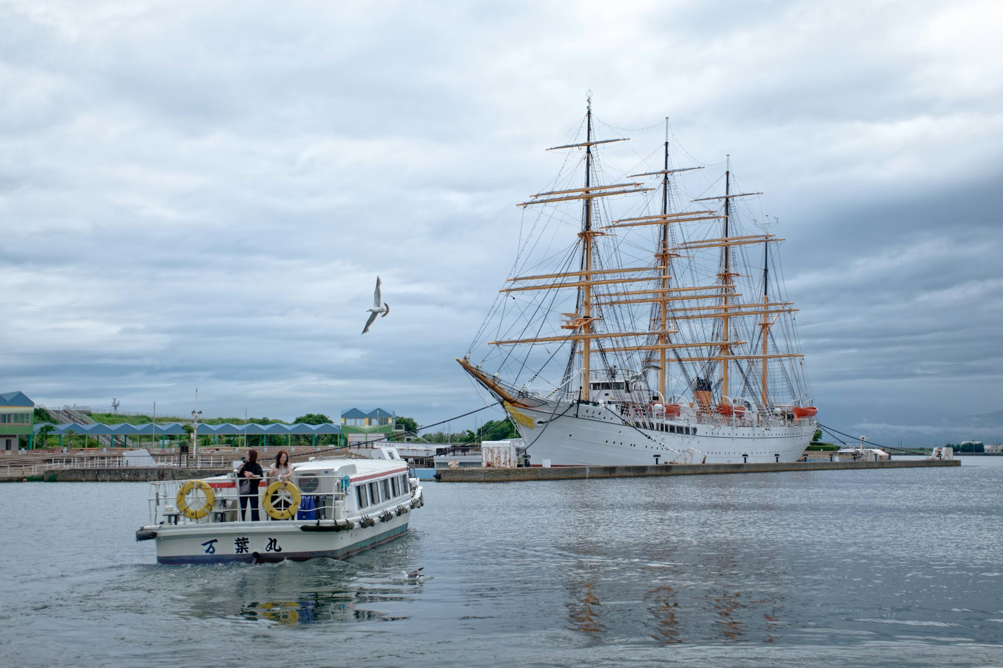 Un gran barco de vela y un bote turístico en el agua