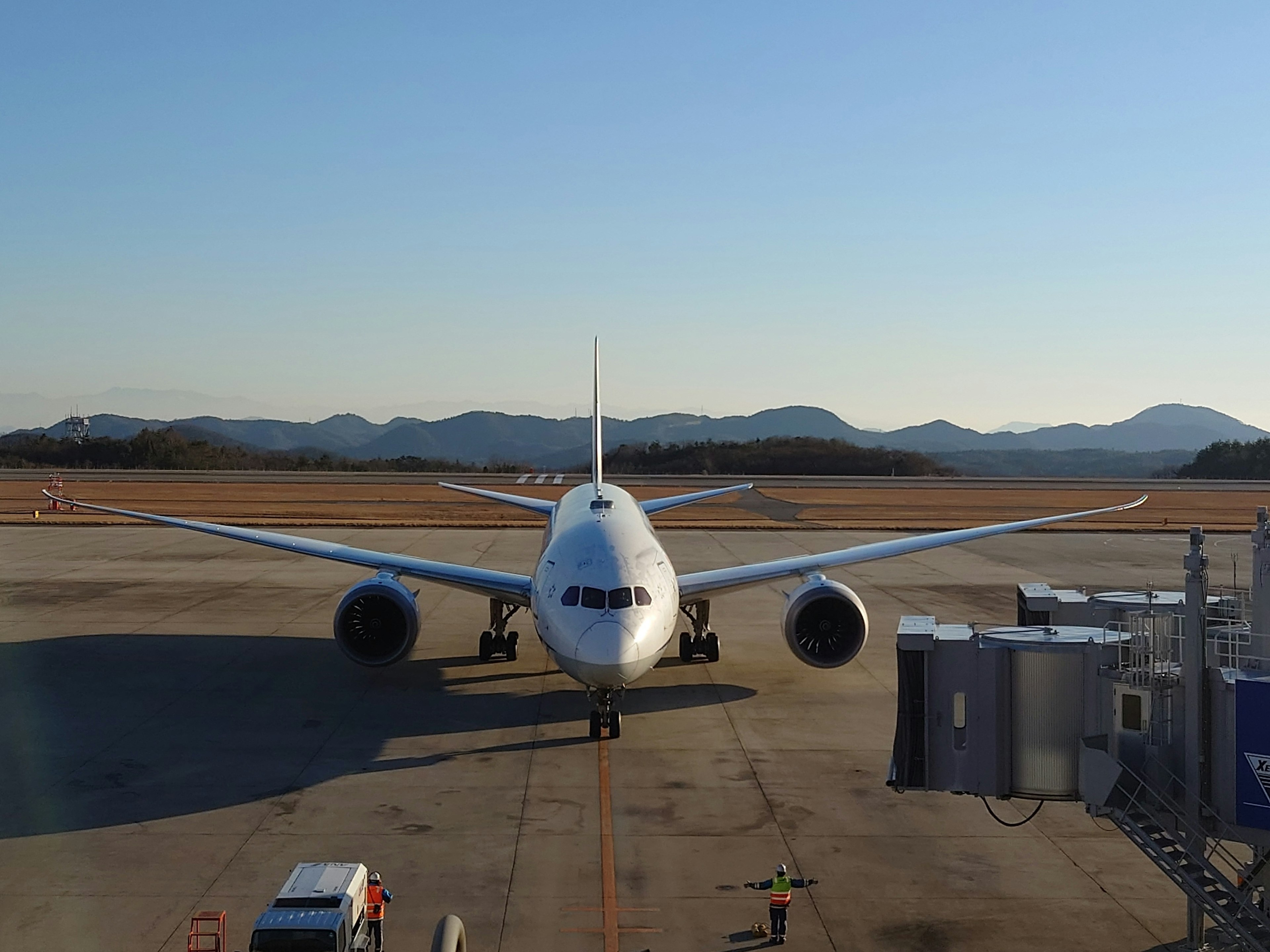 Front view of a Boeing 787 parked on an airport runway