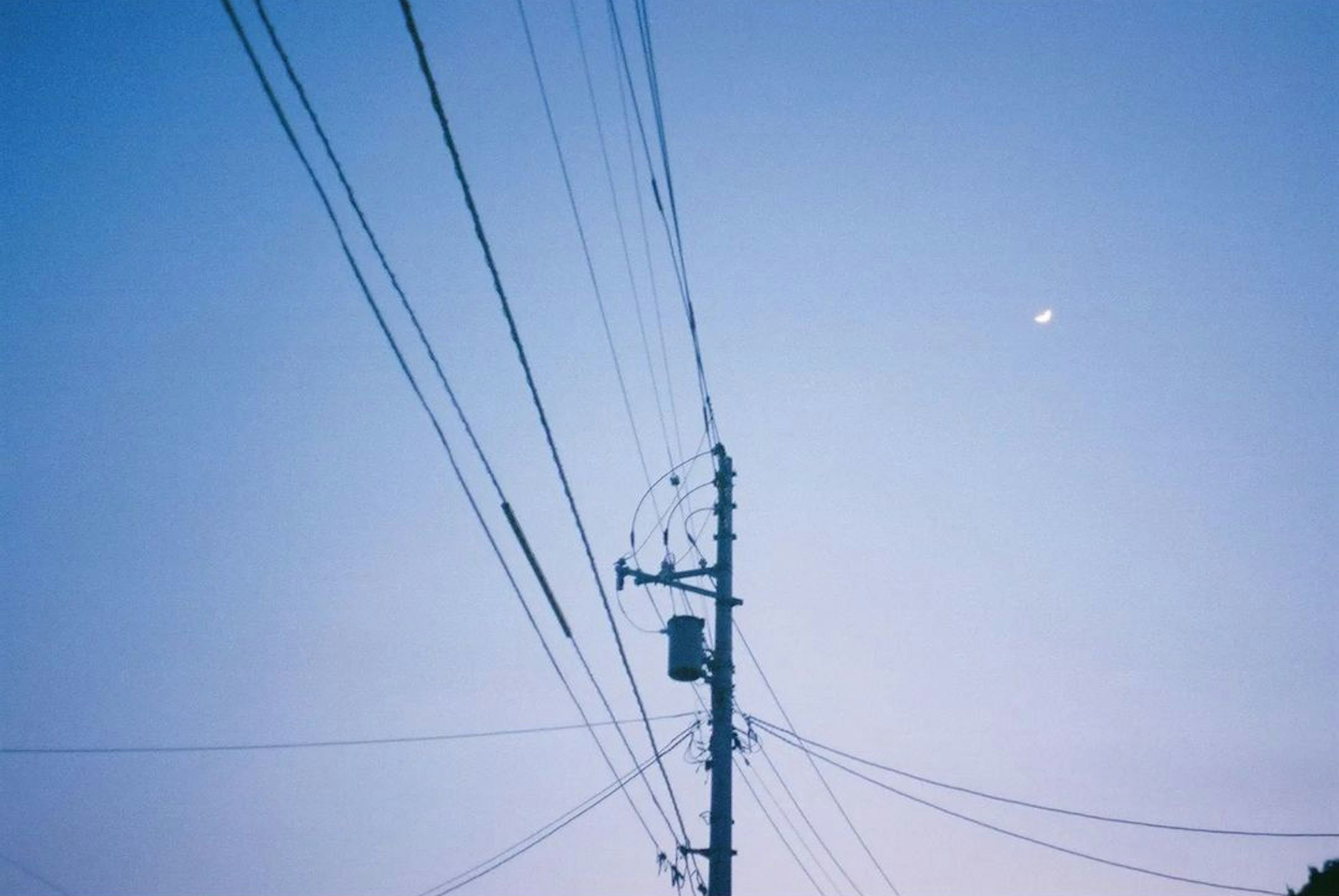 Un poste de luz y cables contra un cielo azul