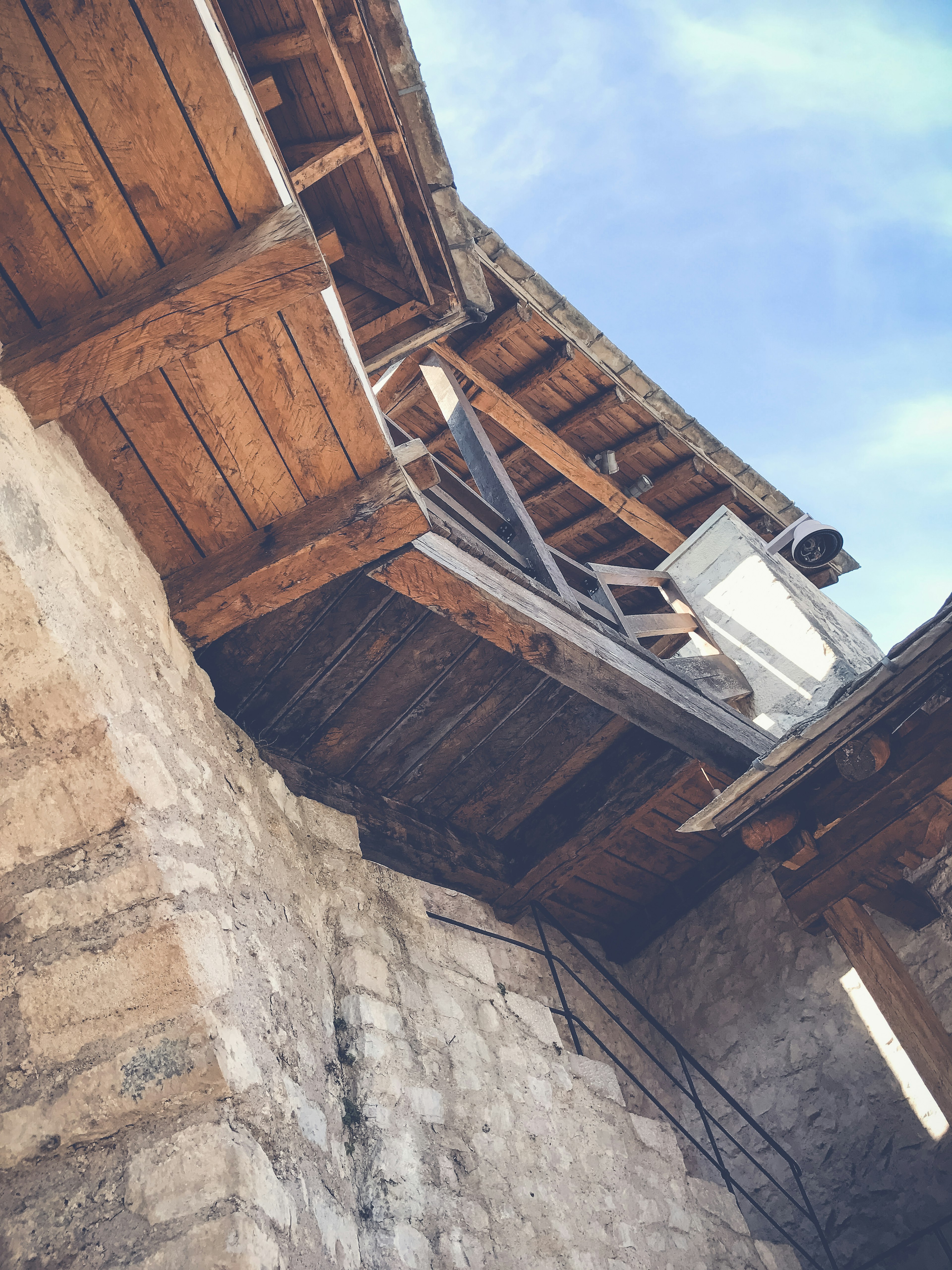 Vue d'en bas d'une section de toit en bois d'un ancien bâtiment en pierre