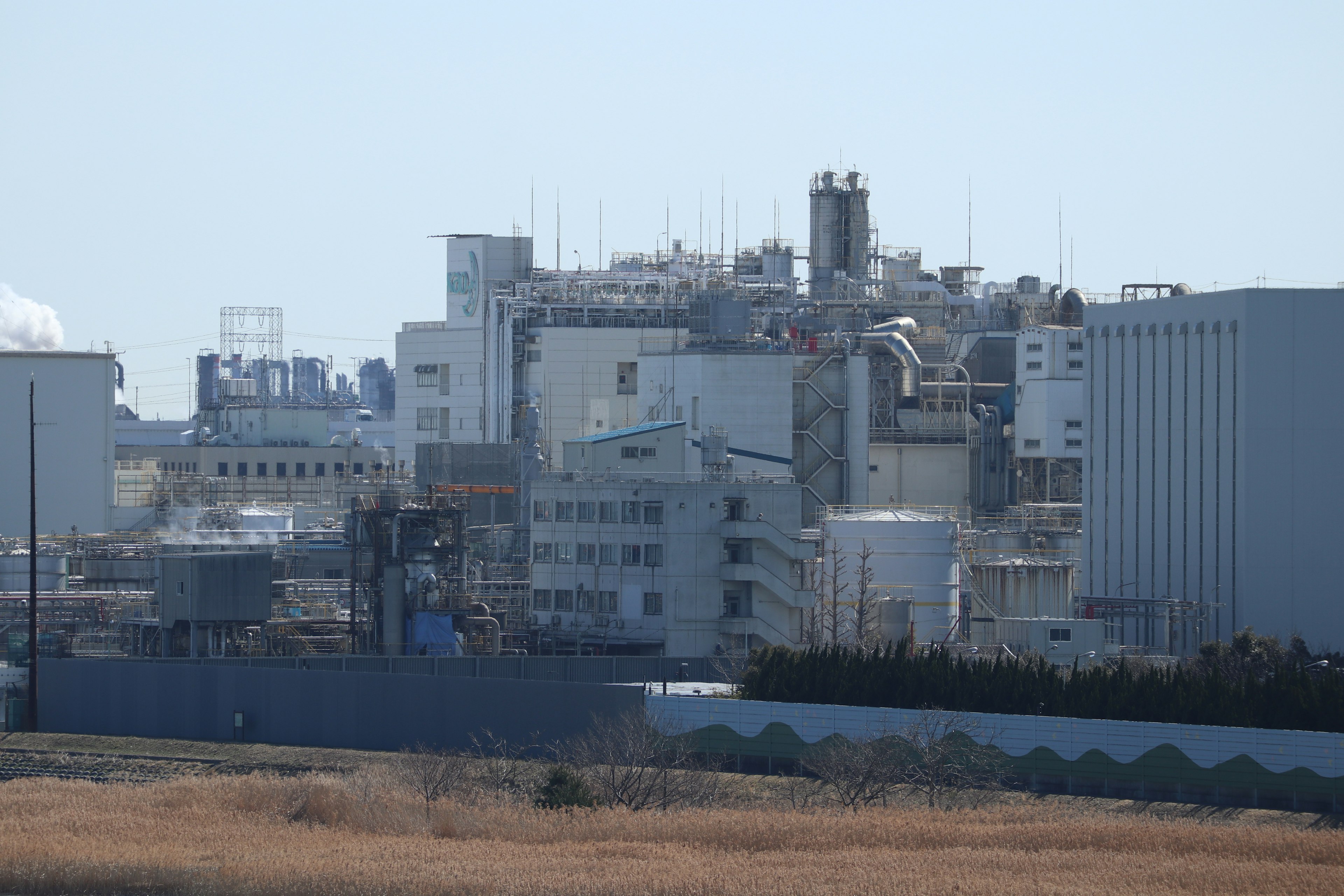 A view of industrial buildings with a grassy foreground