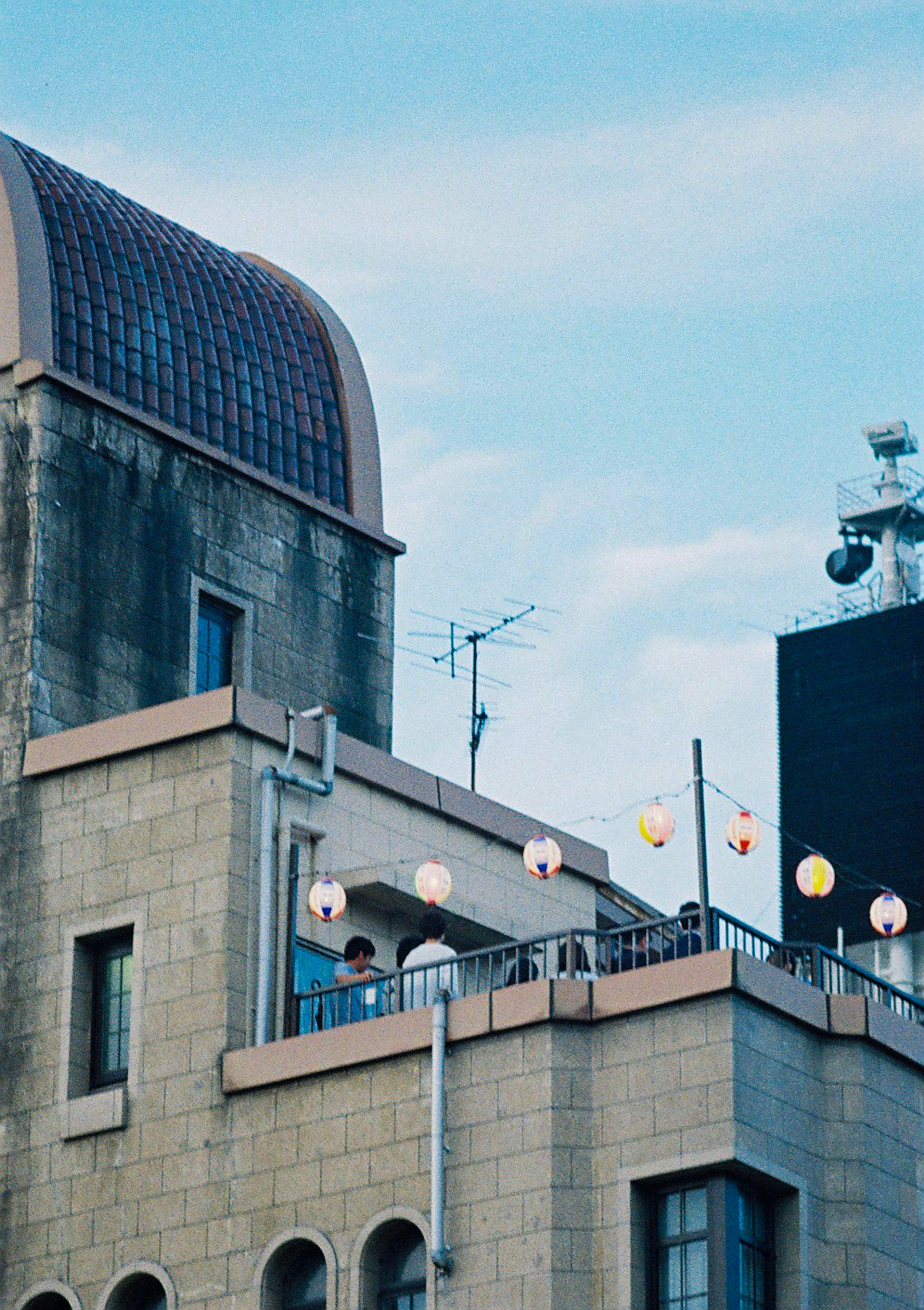 A rooftop view featuring decorative lanterns under a blue sky