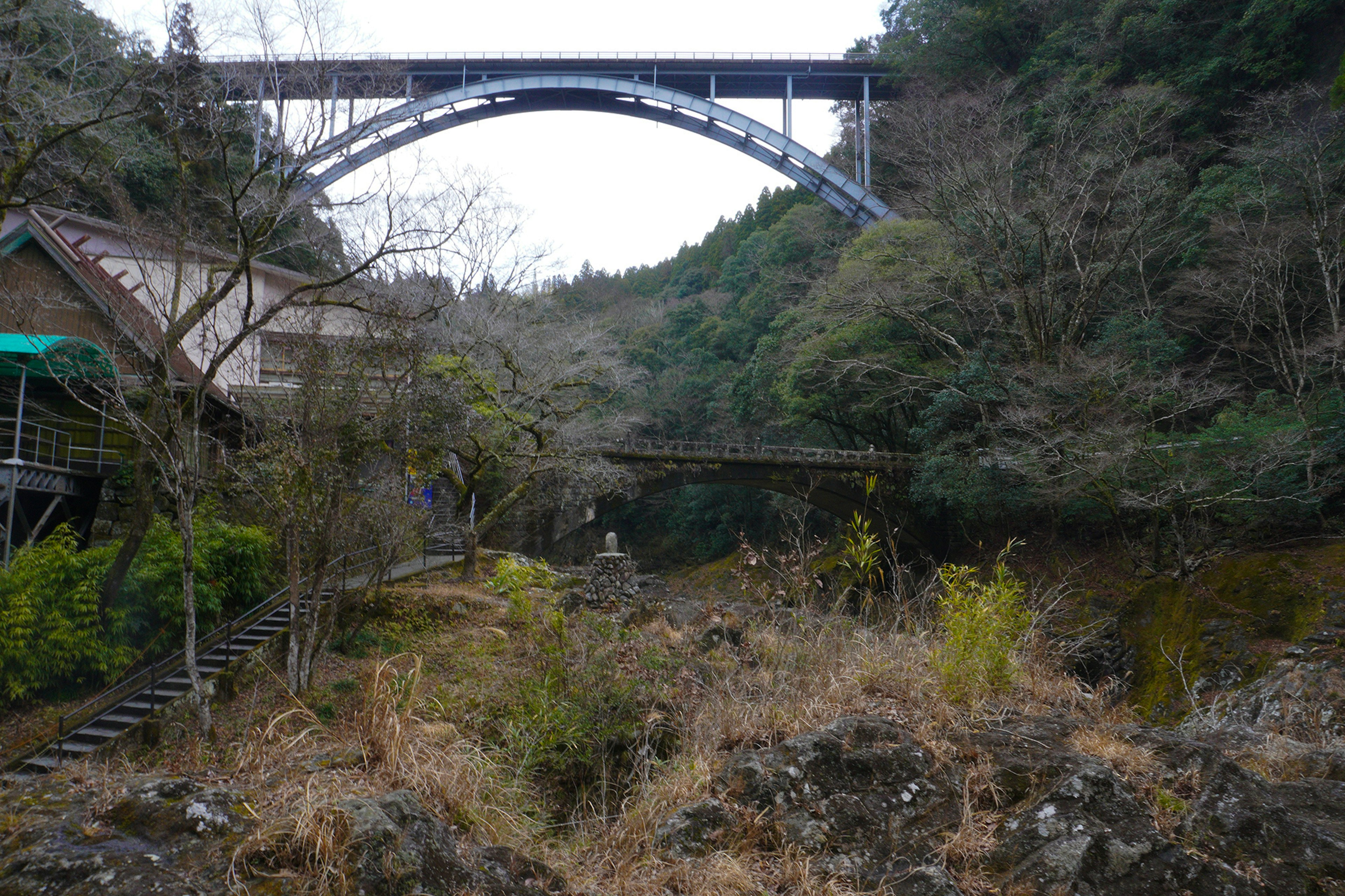 青いアーチ橋と自然の風景が広がる写真