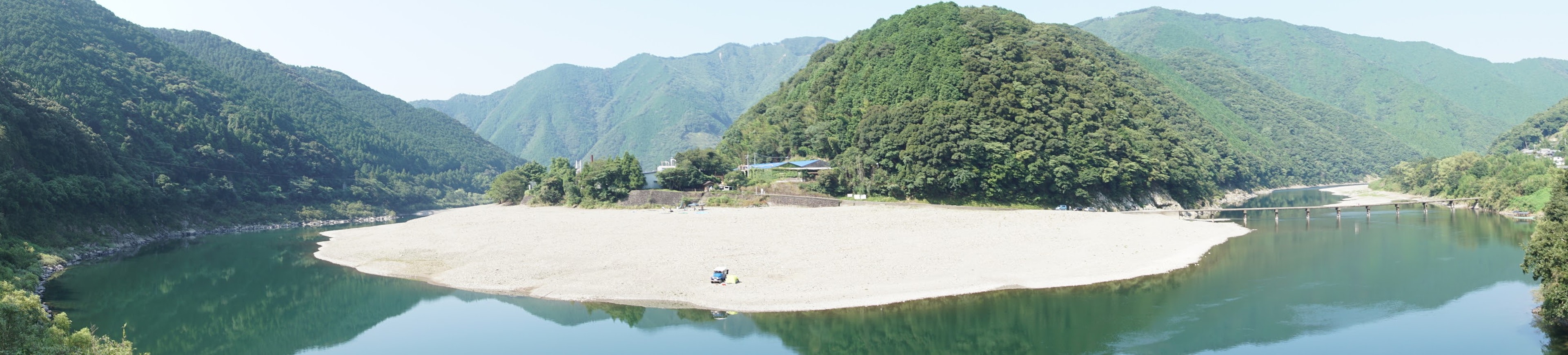 被郁郁葱葱的山脉环绕的宁静湖泊全景