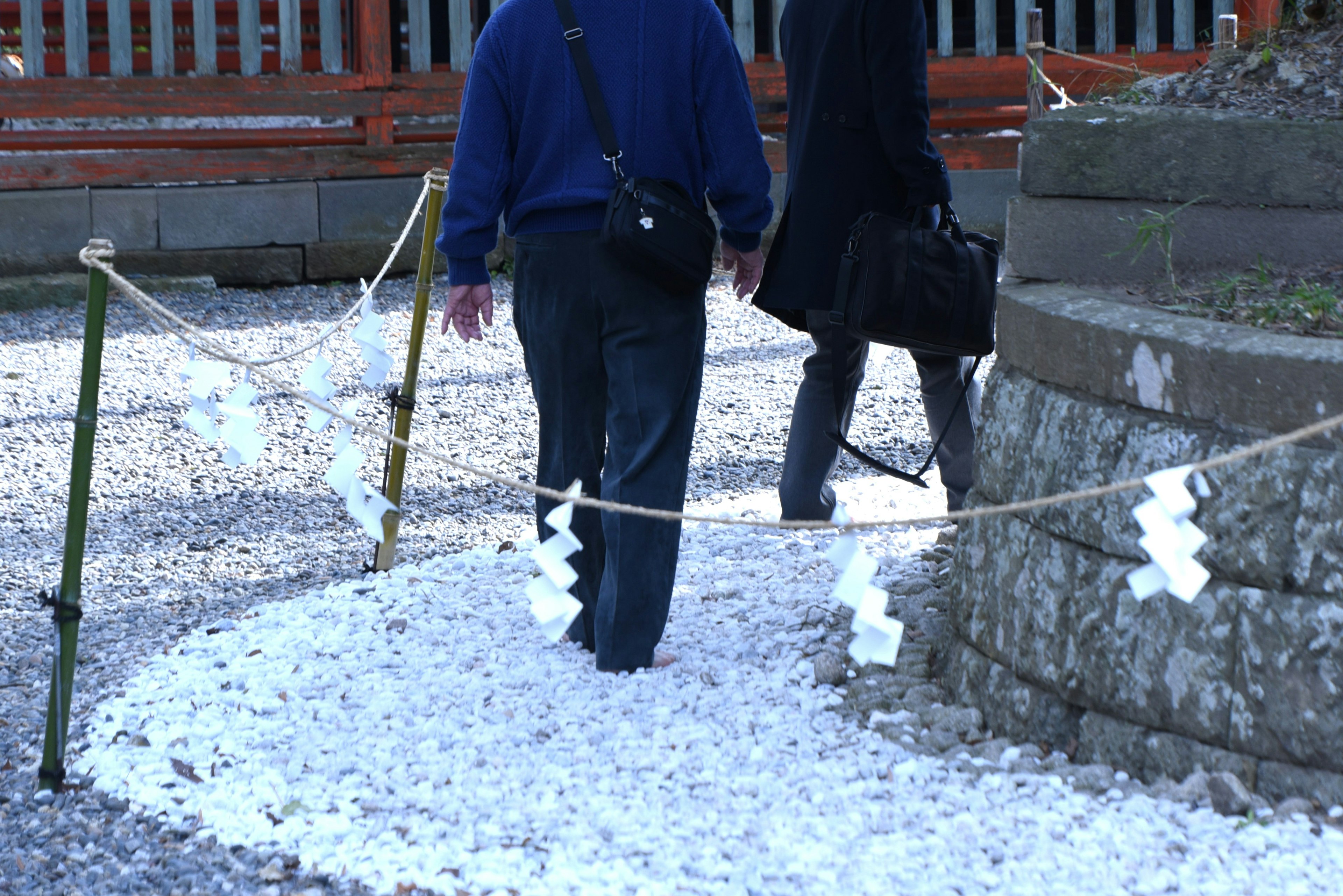 Personas caminando sobre un camino cubierto de pétalos blancos