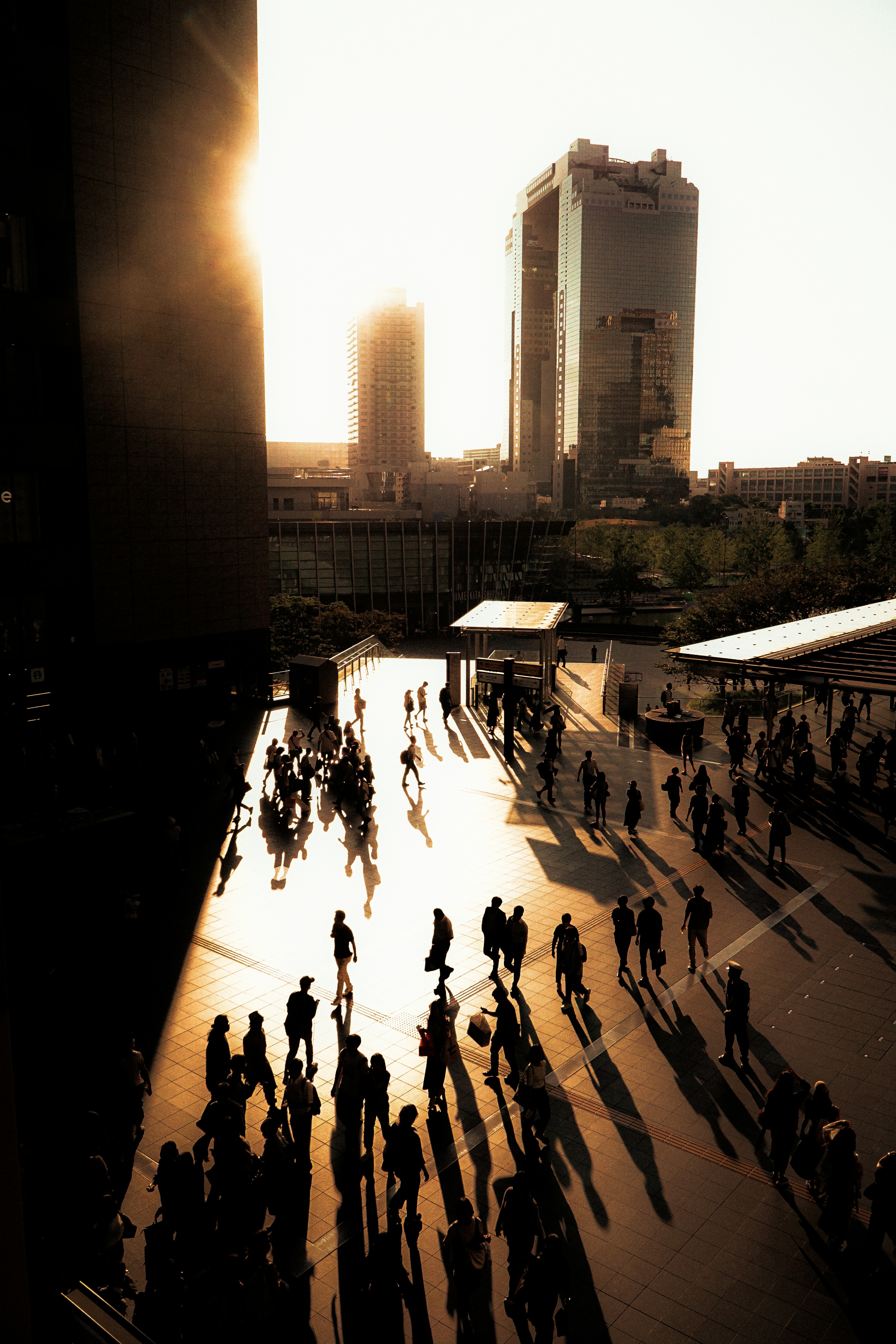 Silhouettes de personnes marchant dans un paysage urbain au coucher du soleil