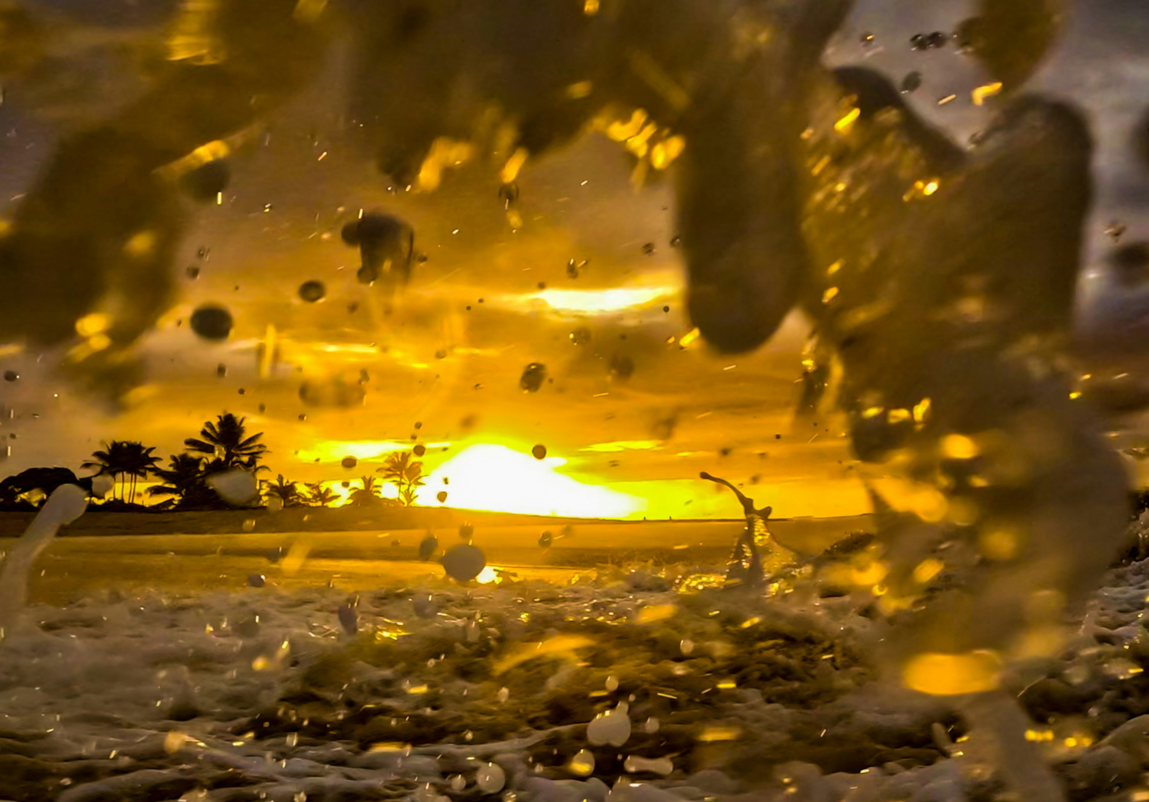 Reflejo dorado del atardecer en las salpicaduras del océano