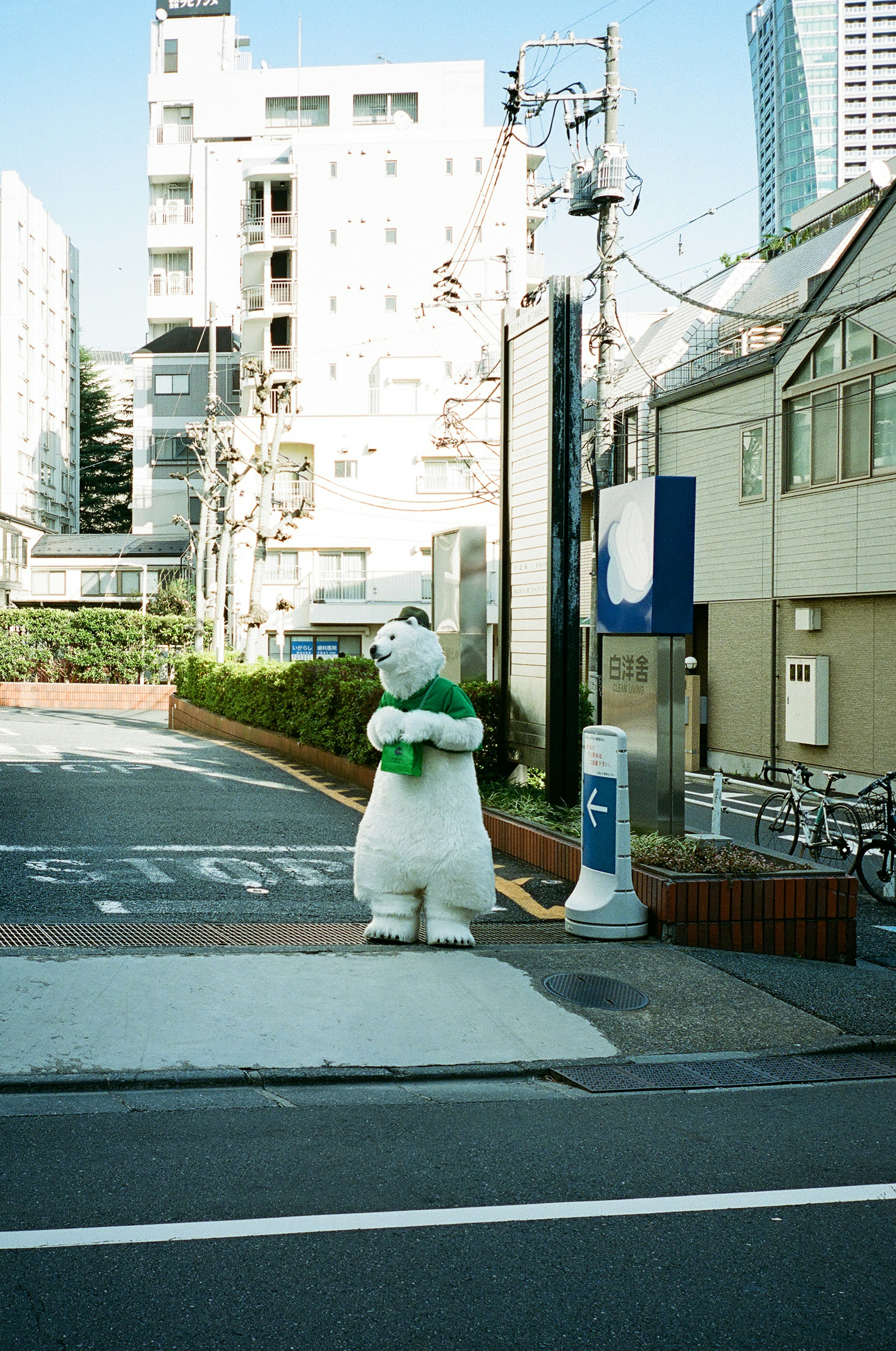 Un personnage mascotte blanc se tenant à un coin de rue