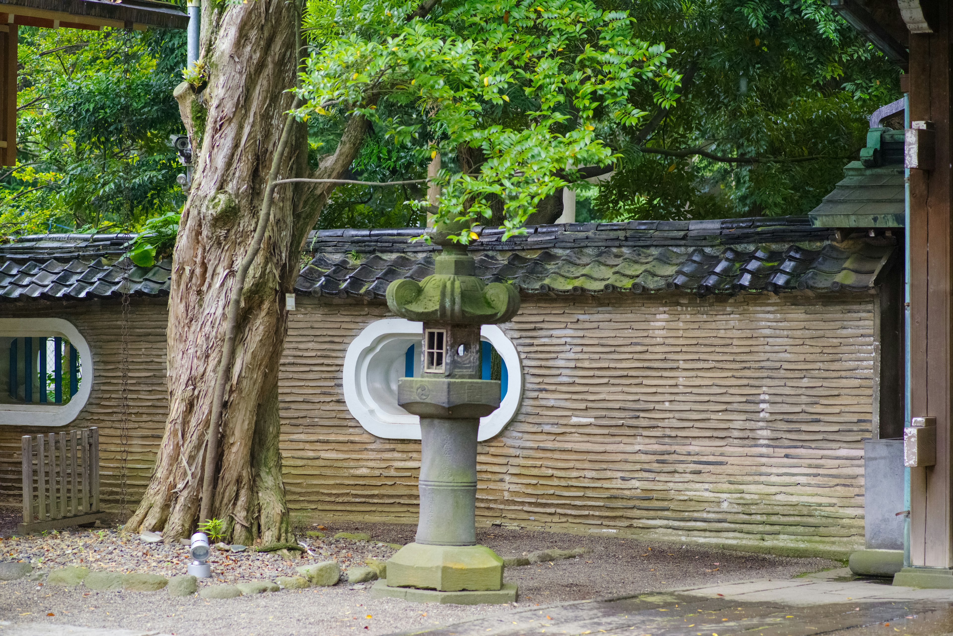 A serene garden scene featuring an ancient stone lantern and lush greenery