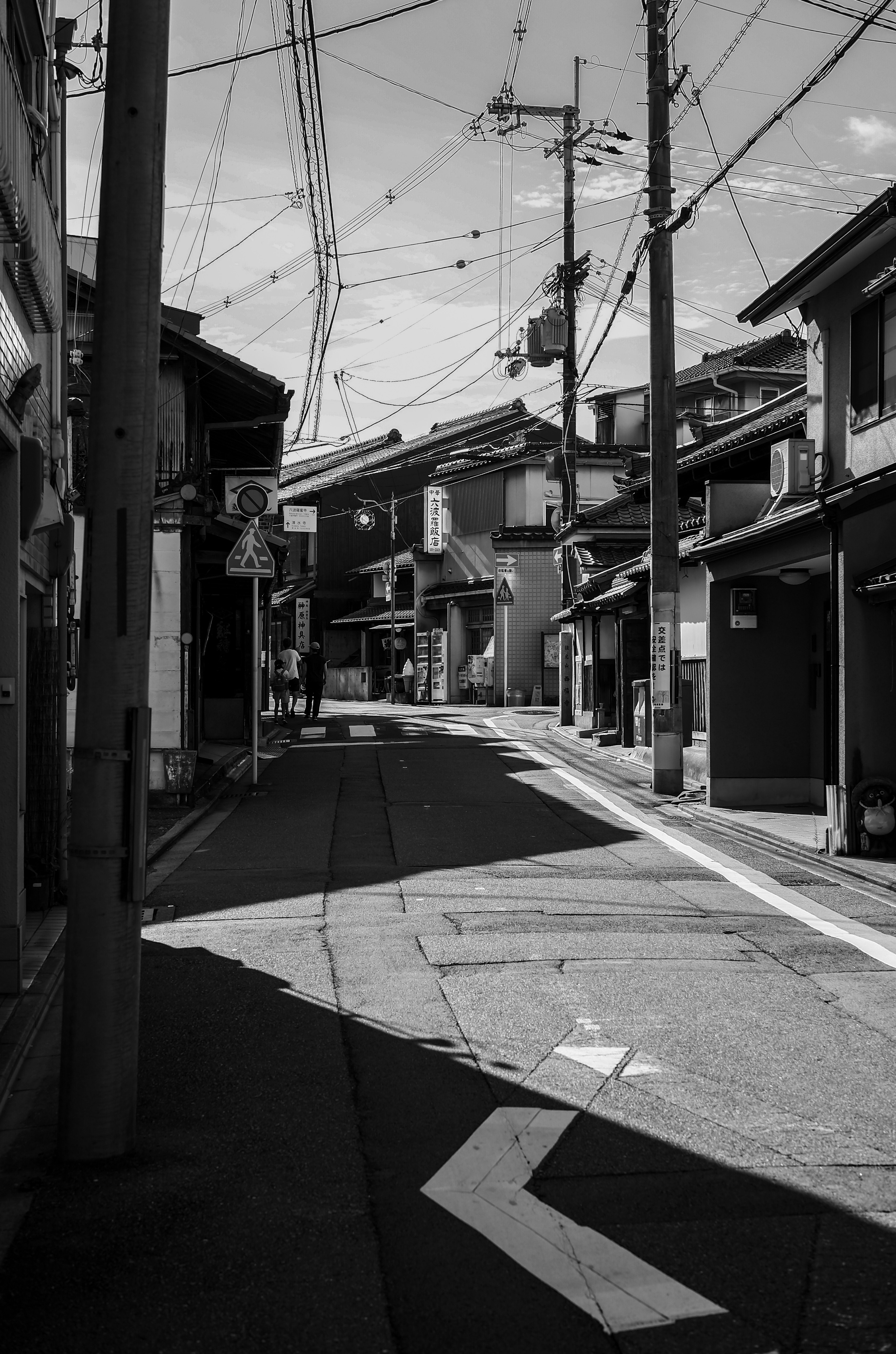 Strada stretta con una curva e vecchi edifici in bianco e nero