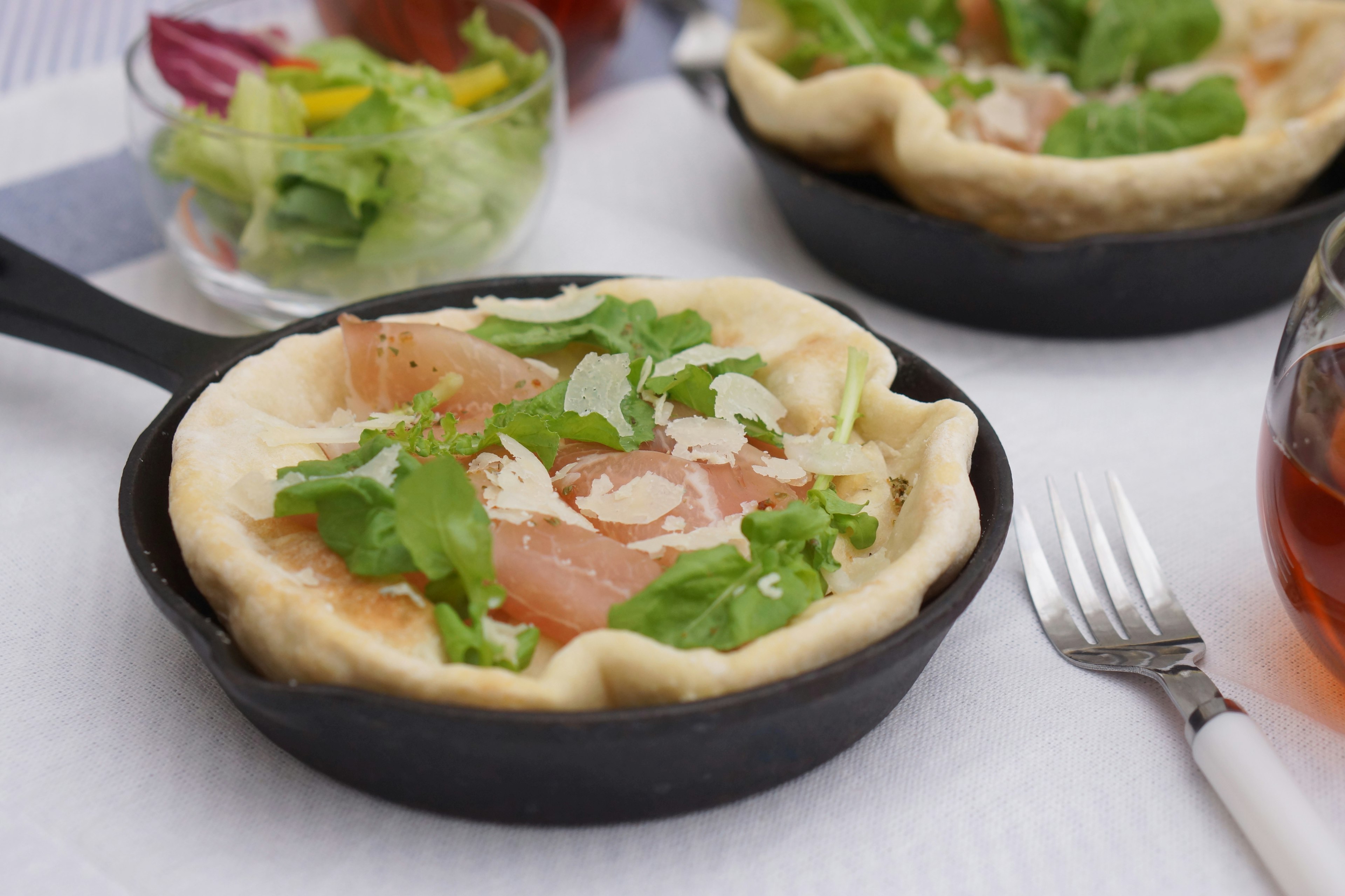 Plato con salmón ahumado y ensalada servido en una sartén de hierro fundido