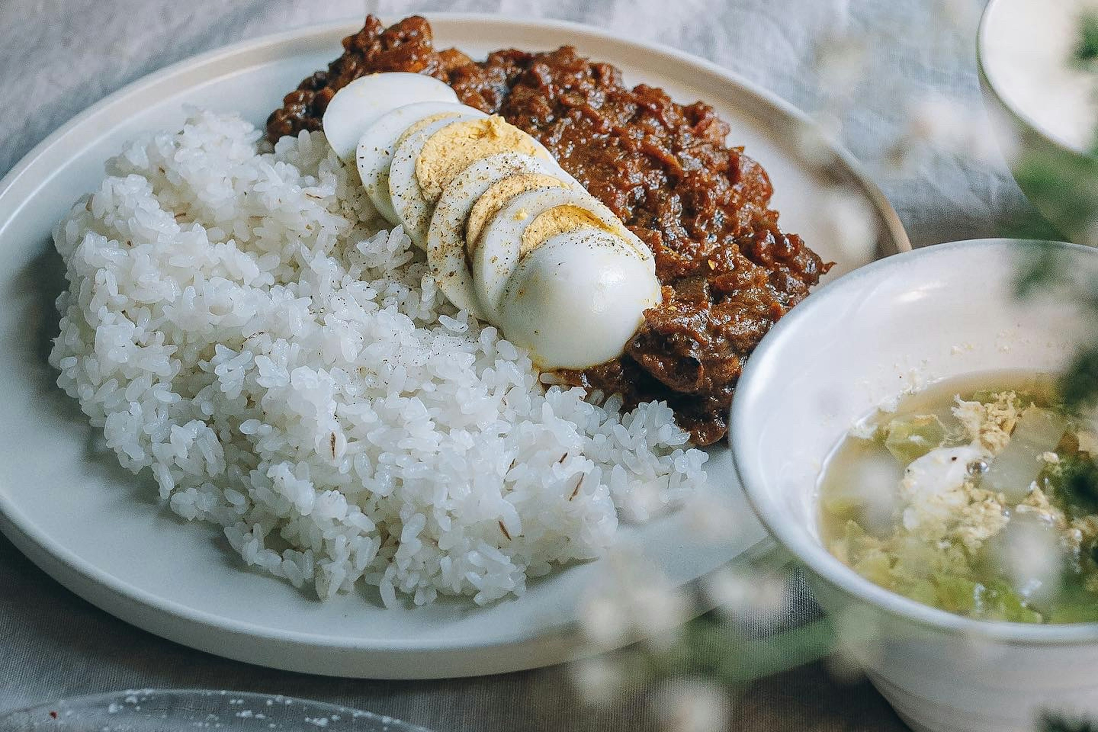 飯配牛肉和煮蛋的盤子