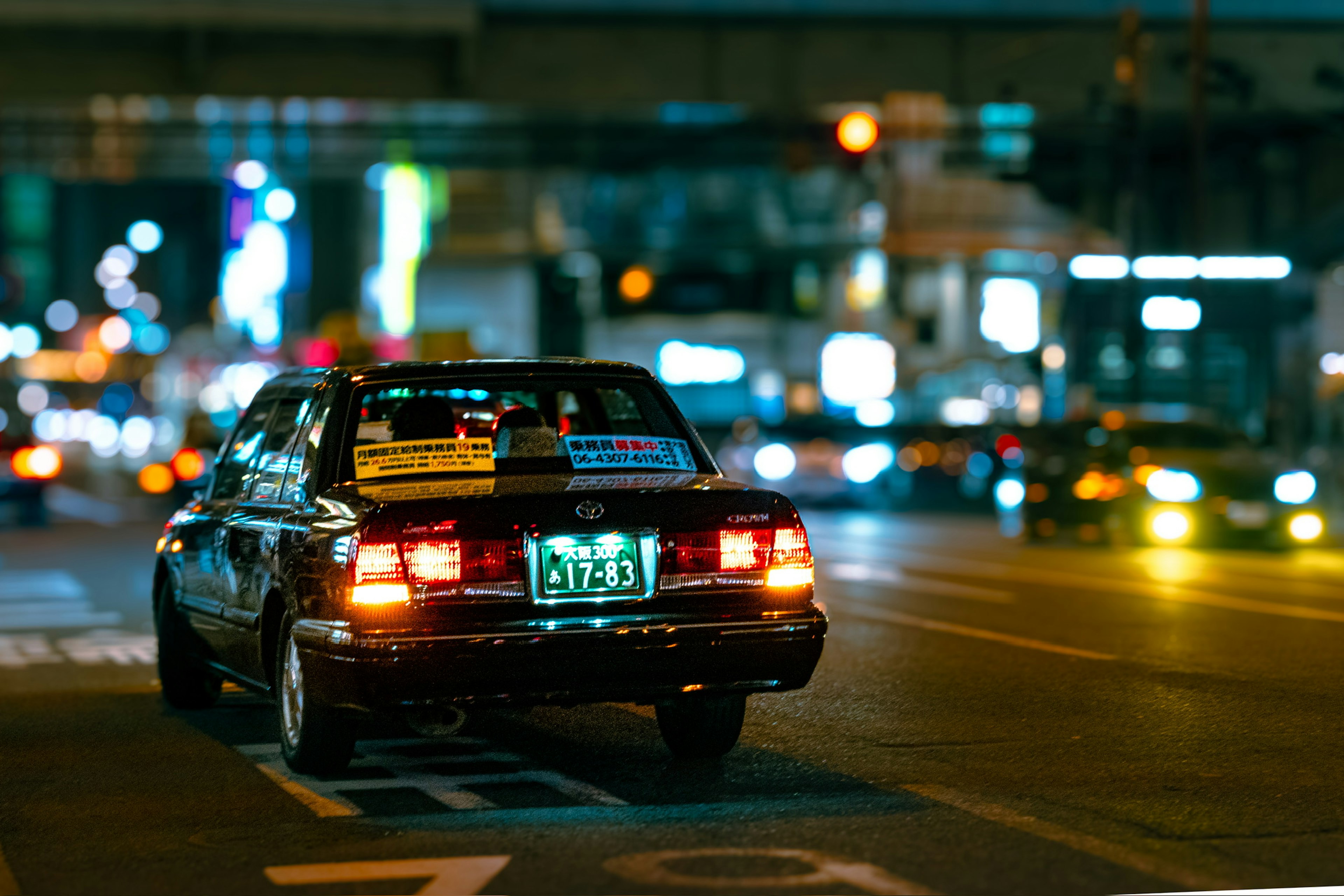 Taxi driving through a vibrant city at night with bright street lights