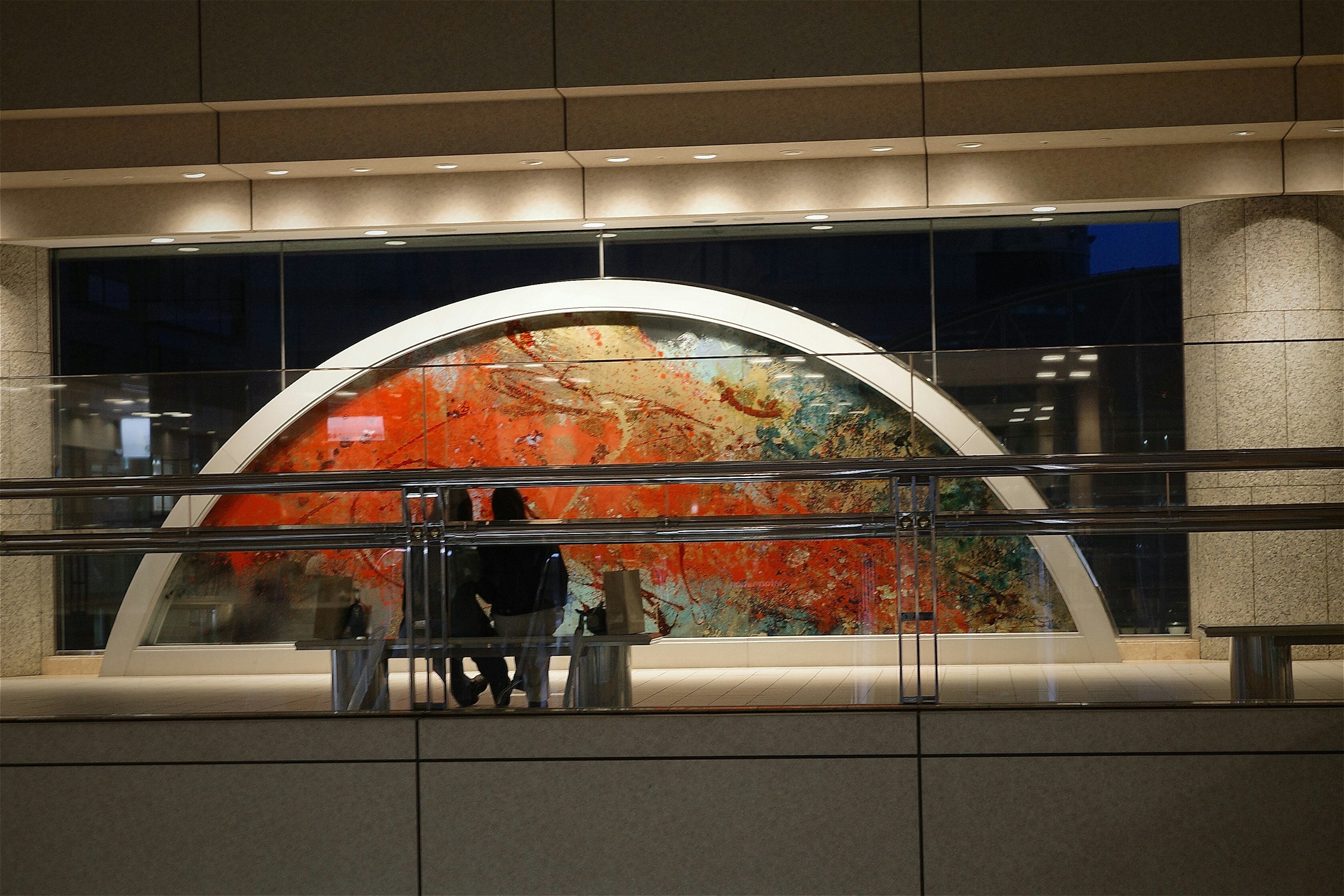 Silhouette of a couple sitting in front of an artistic mural