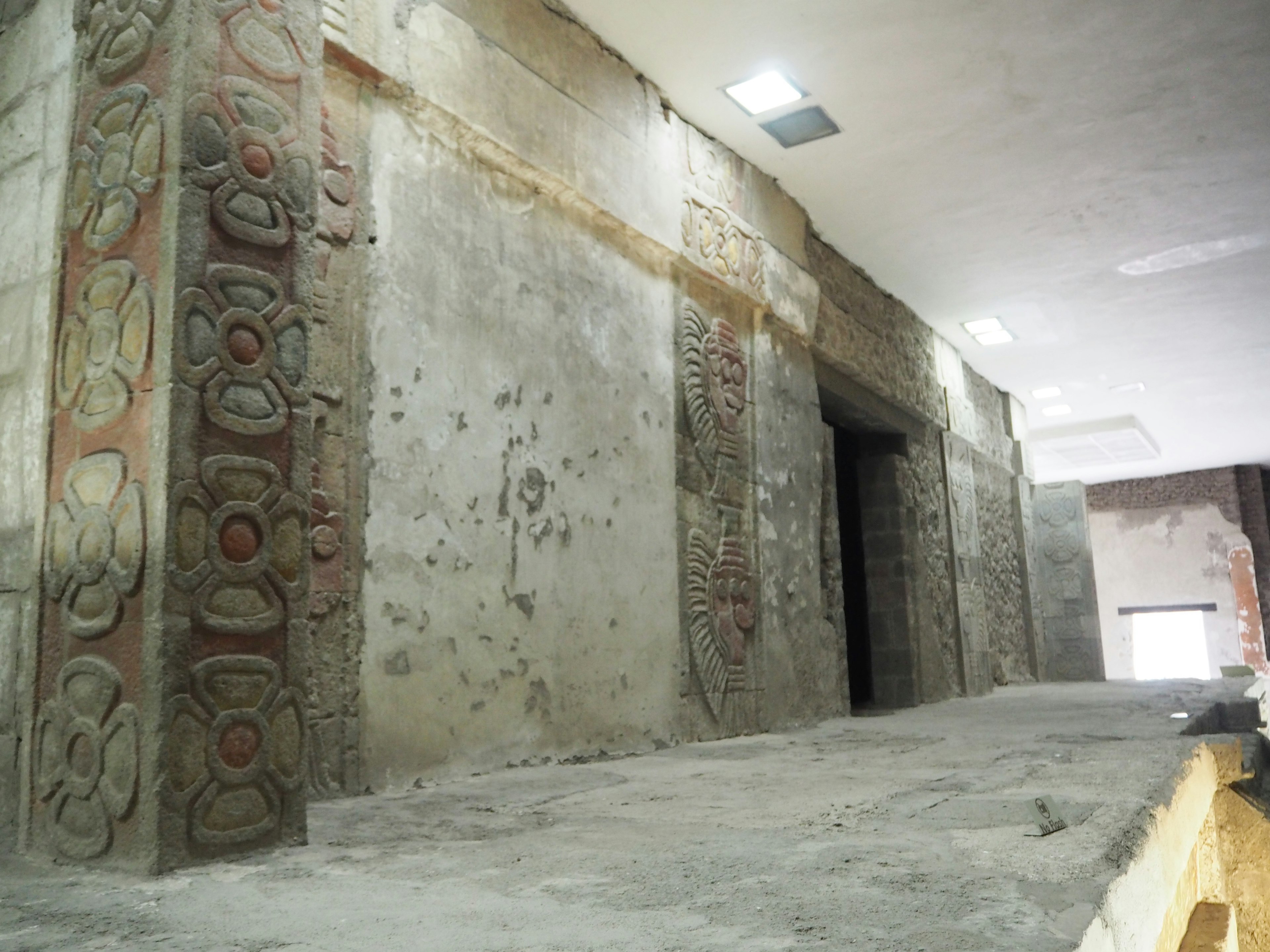 Vista interior de un sitio antiguo con murales y tallas decorativas