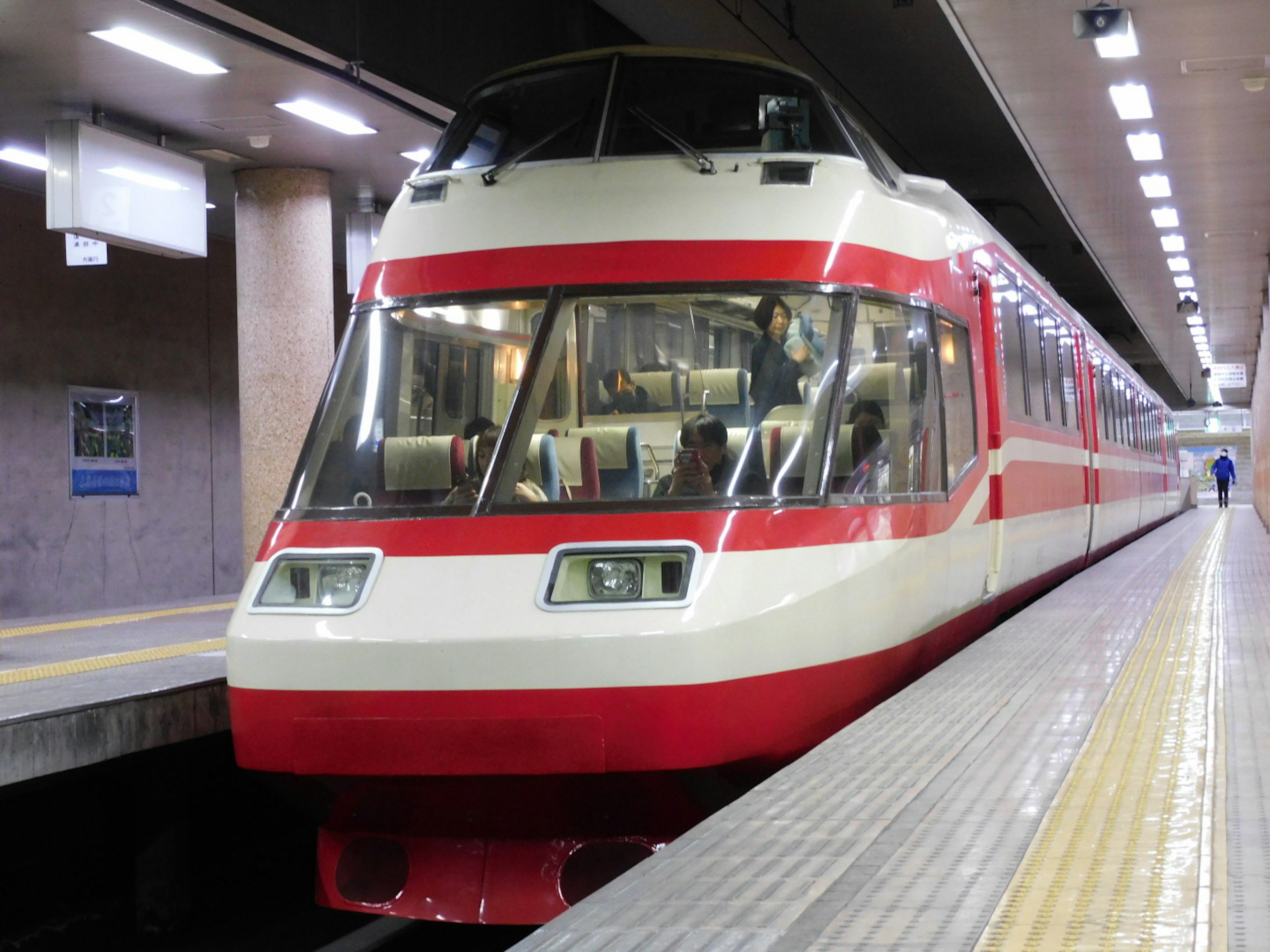 Kereta modern berwarna merah dan putih berhenti di stasiun