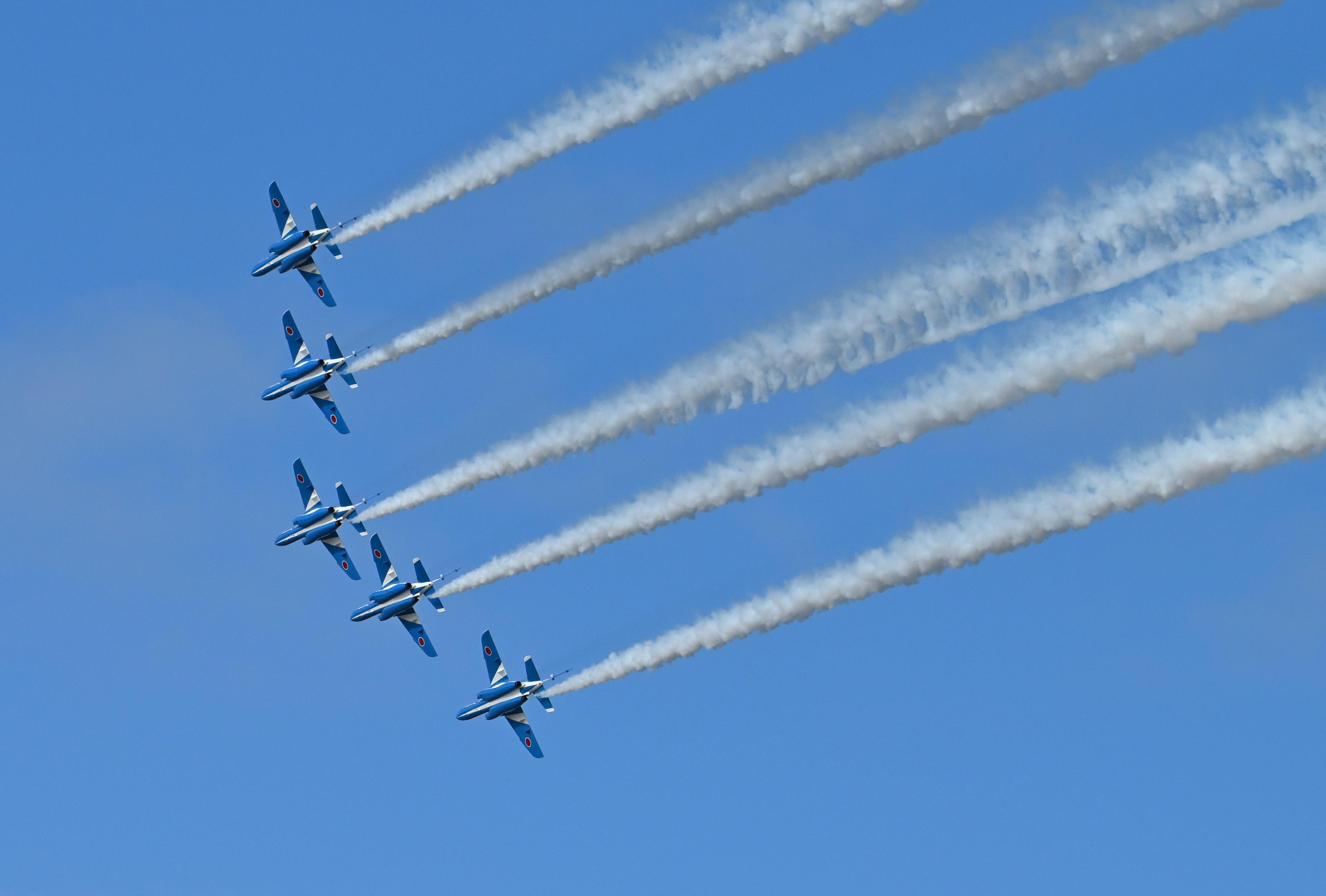 Formationsflug von fünf Flugzeugen, die gegen einen blauen Himmel auftreten