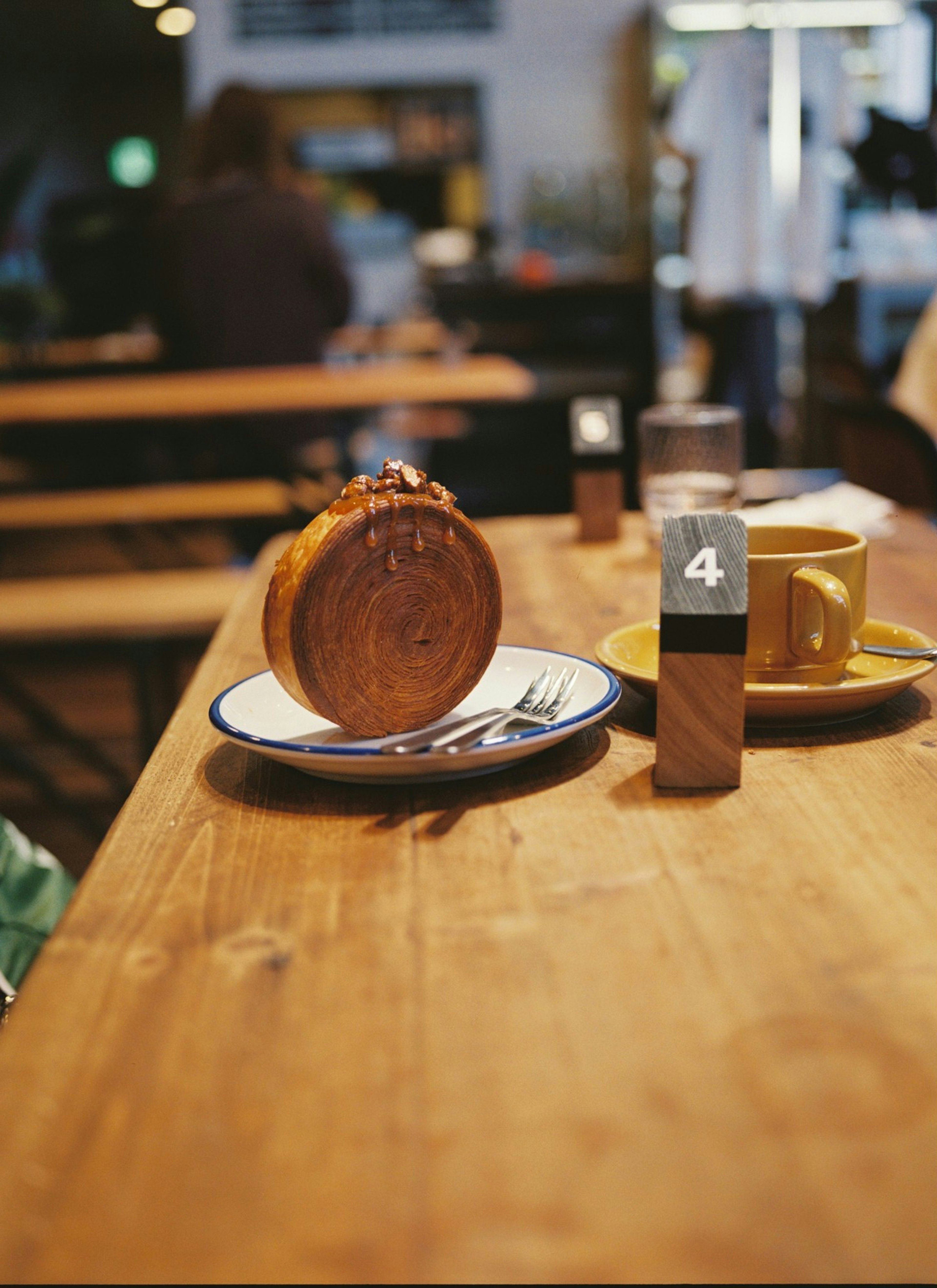 Una mesa de madera con una taza de café y un plato de postre