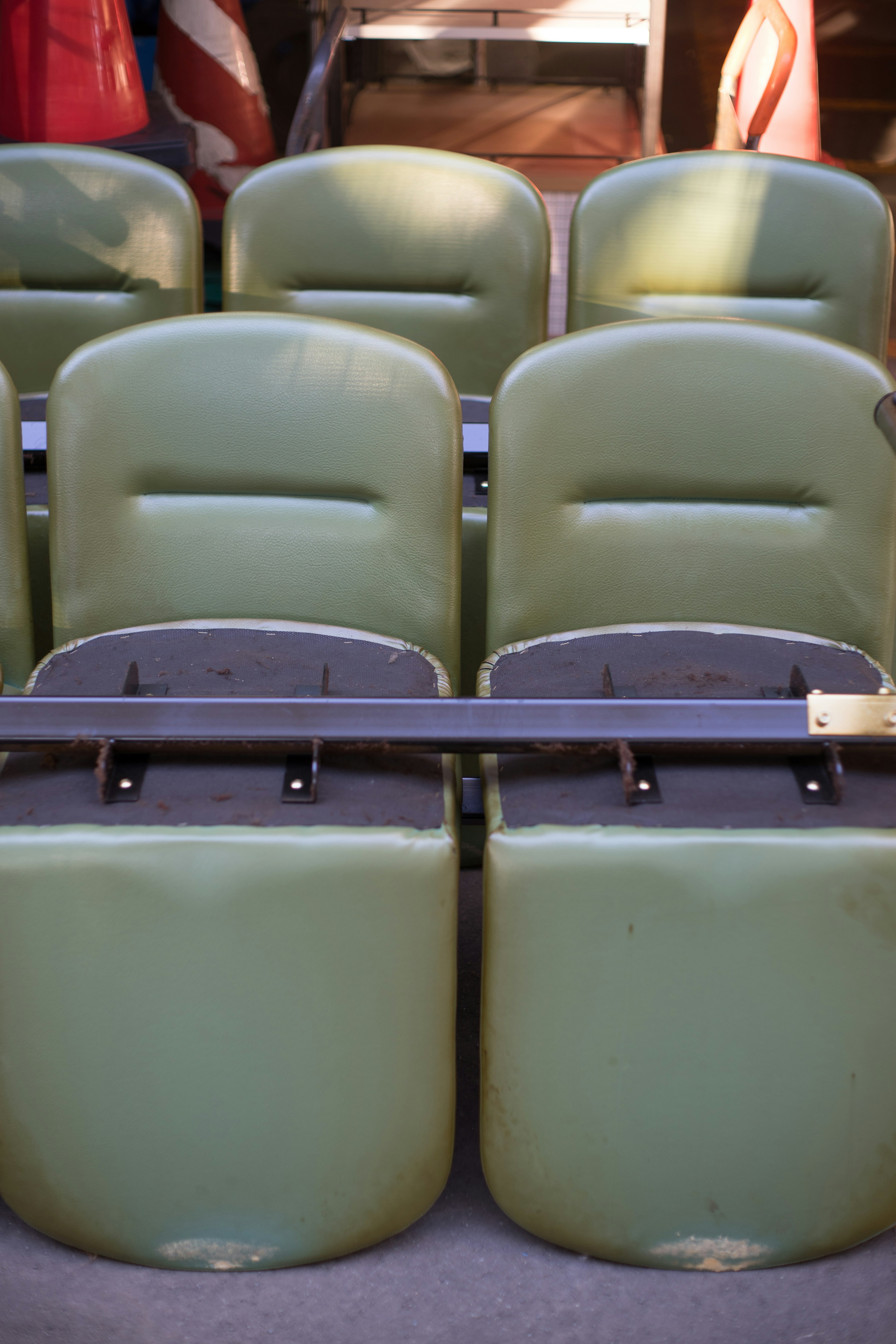 Row of green stadium seats arranged in a neat line