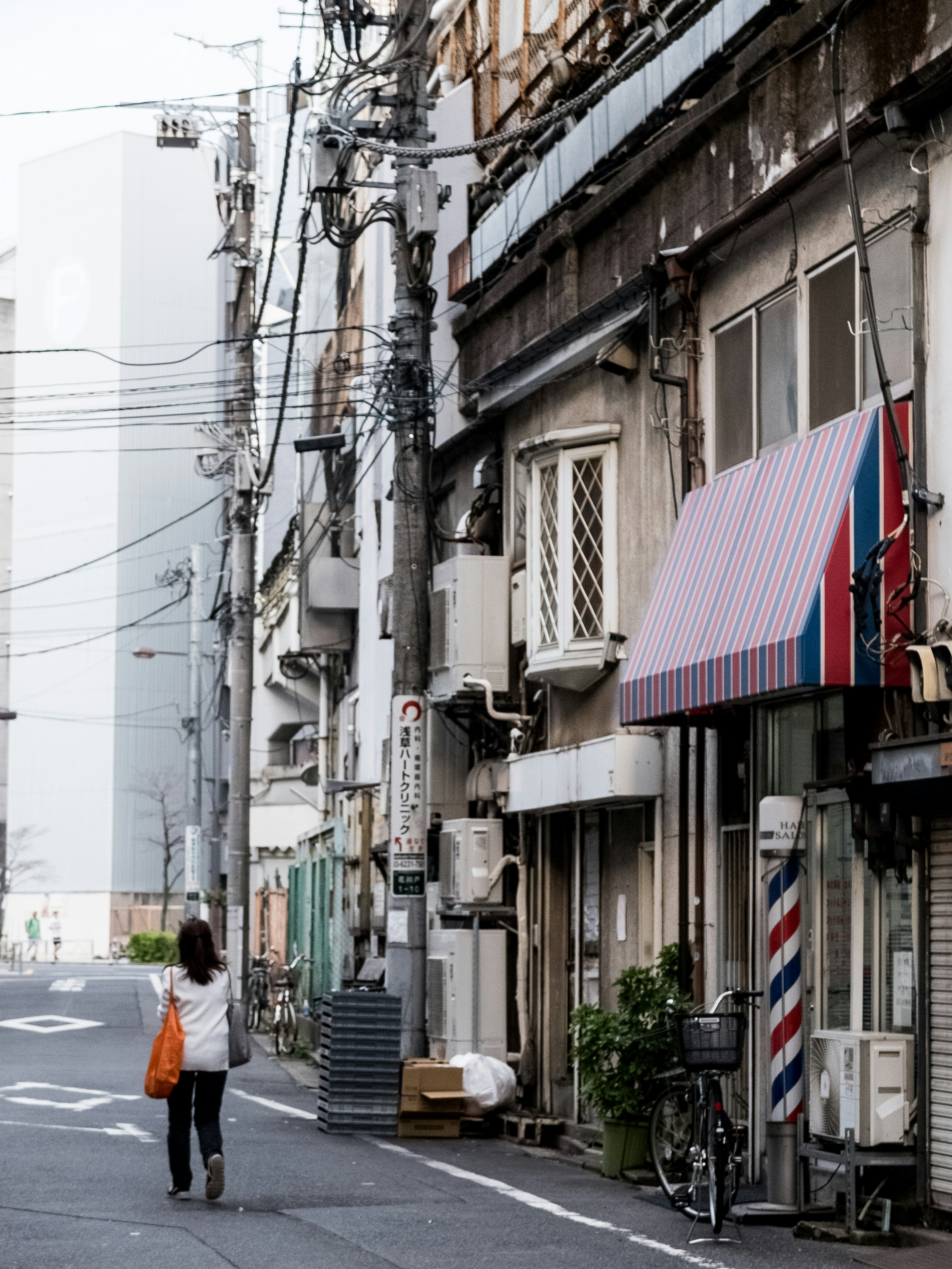 A woman walking down a street lined with old buildings