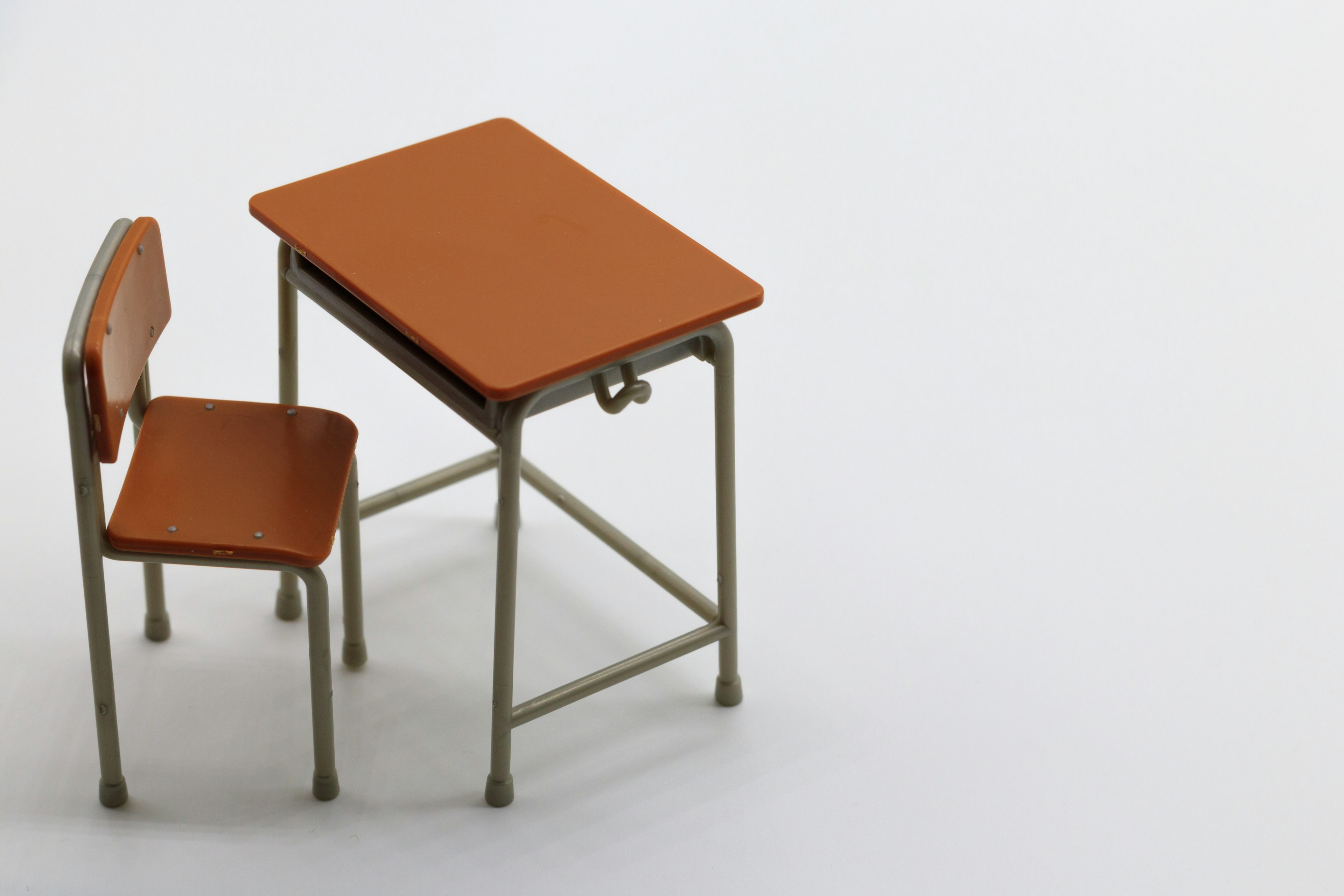 Small brown desk and chair on a white background