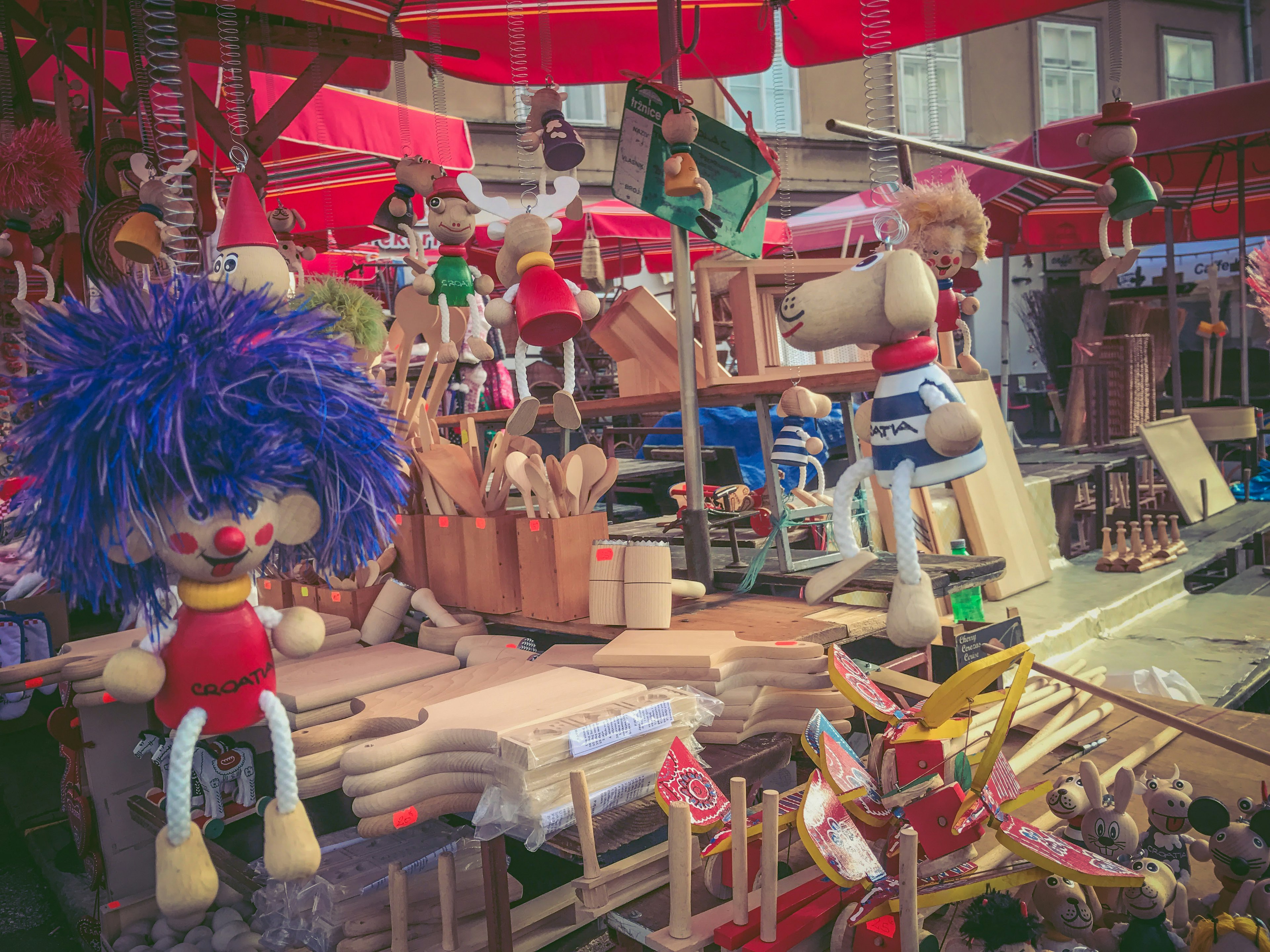 Des poupées colorées et des jouets en bois exposés dans une scène de marché animée