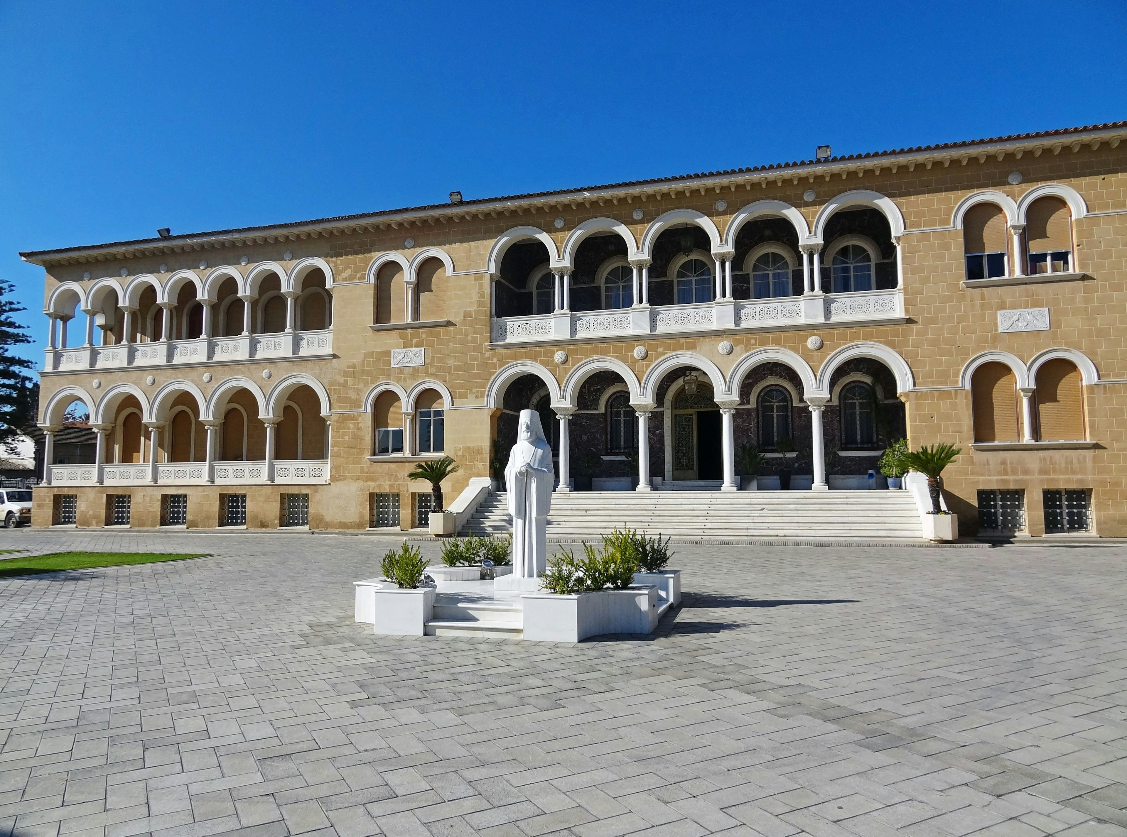 A beautiful building with arches and a statue in the square