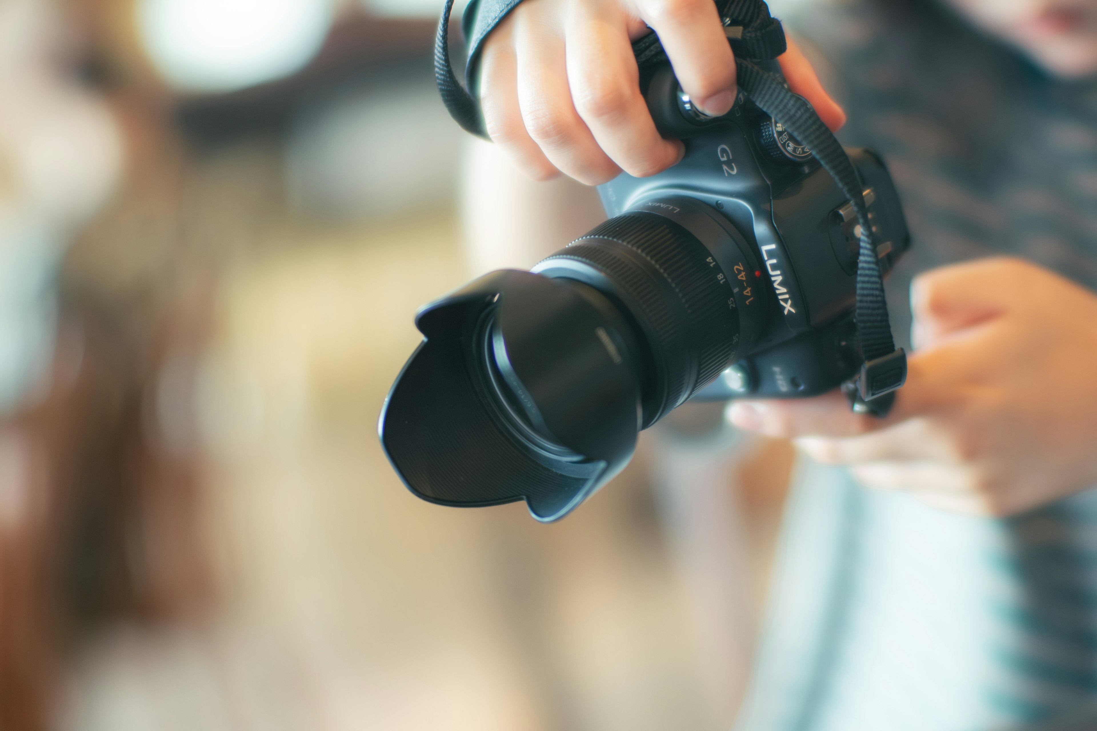 Close-up of a hand holding a high-quality digital camera