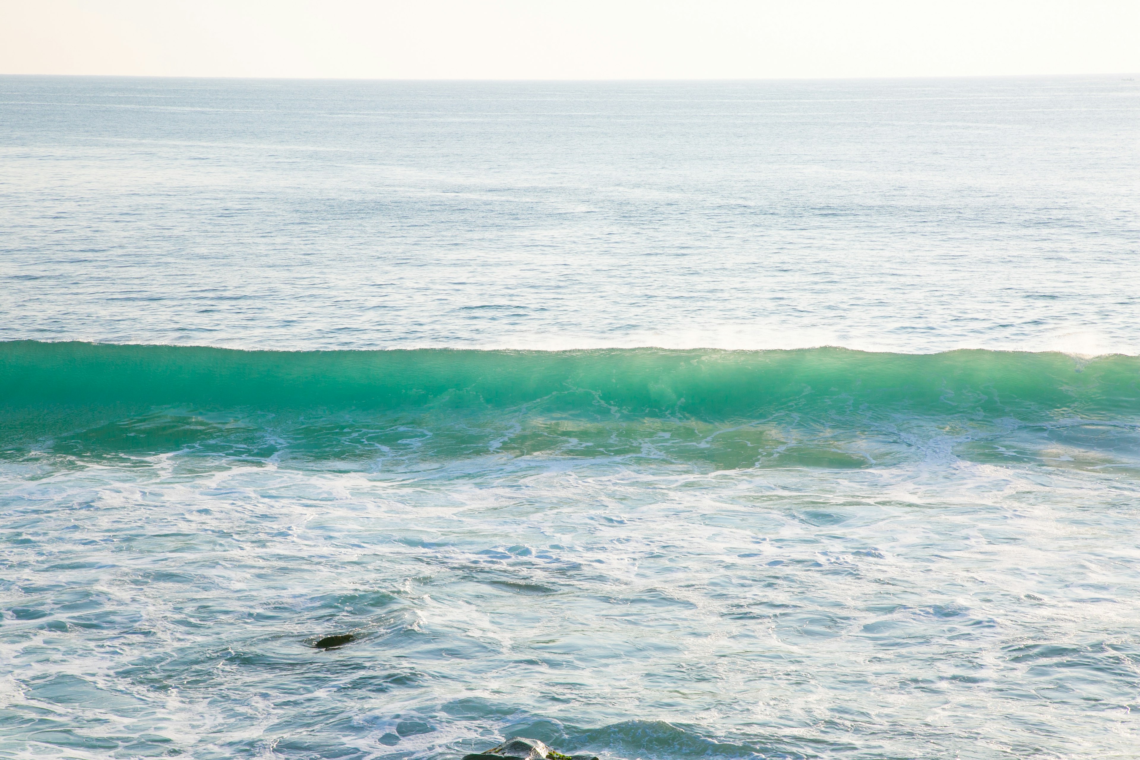 Olas de océano azul tranquilo rompiendo suavemente en la orilla