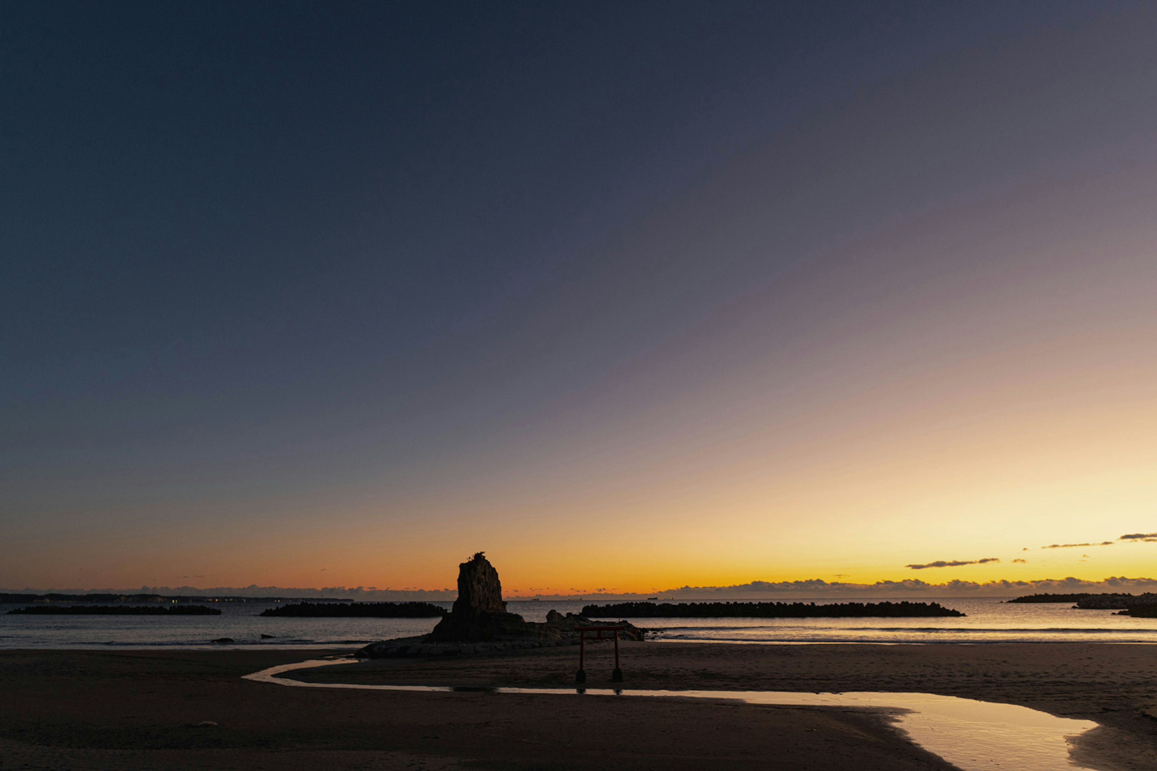 夕日の美しい海岸線に立つ岩の形成