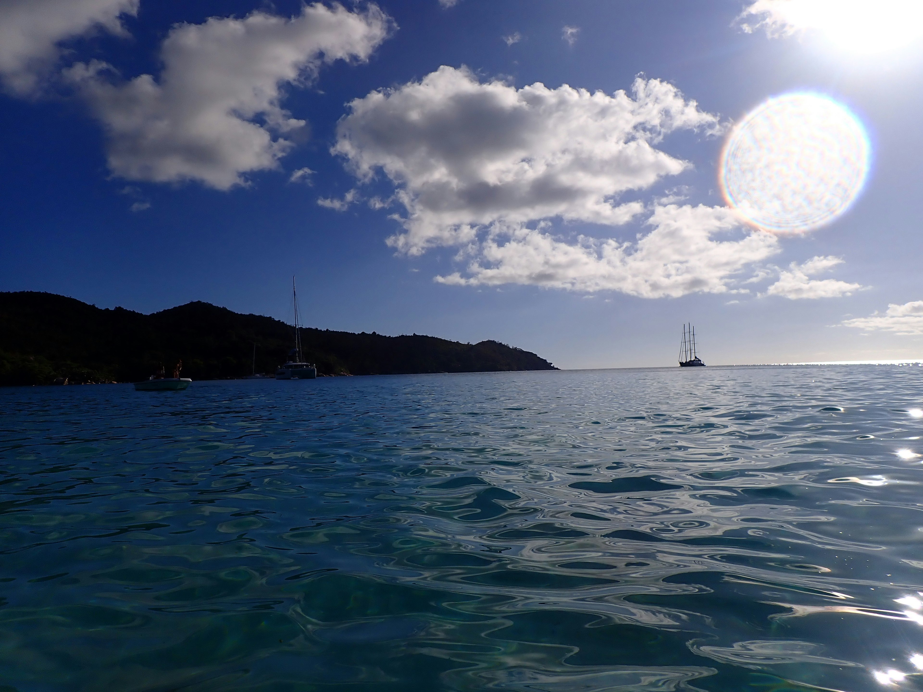 Vista panoramica dell'oceano blu e del cielo con barche e nuvole