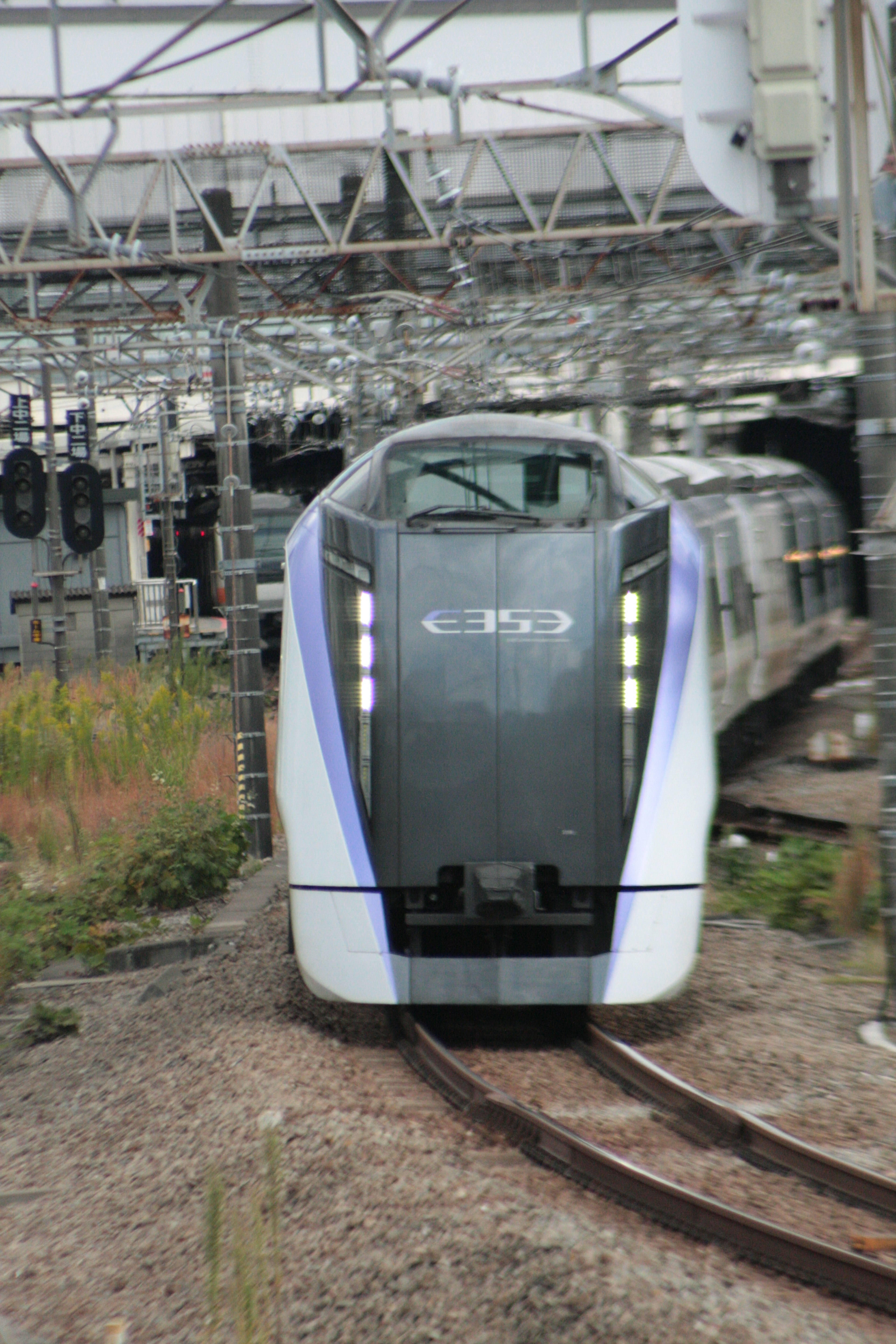 白と黒のデザインの電車が線路に停車中