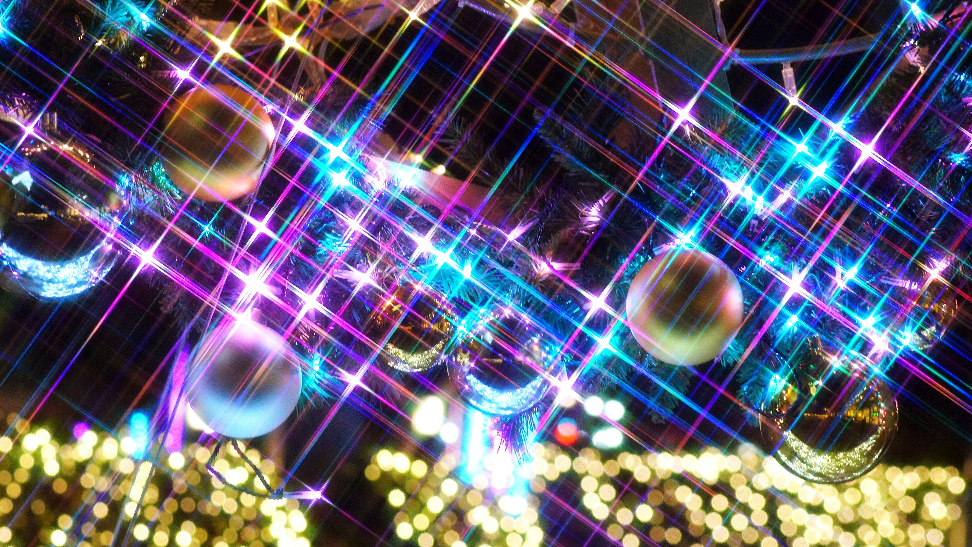 Close-up of colorful lights and star-like sparkles on Christmas ornaments