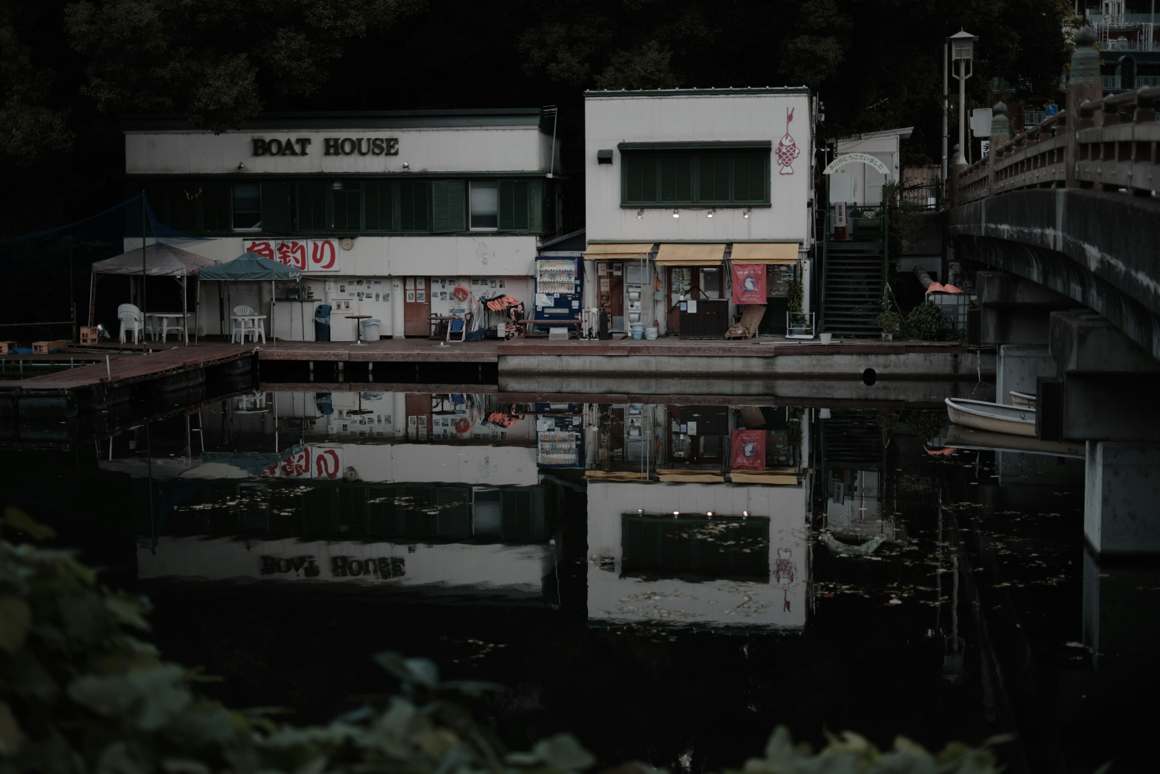 Reflections of a building and surroundings on a calm water surface