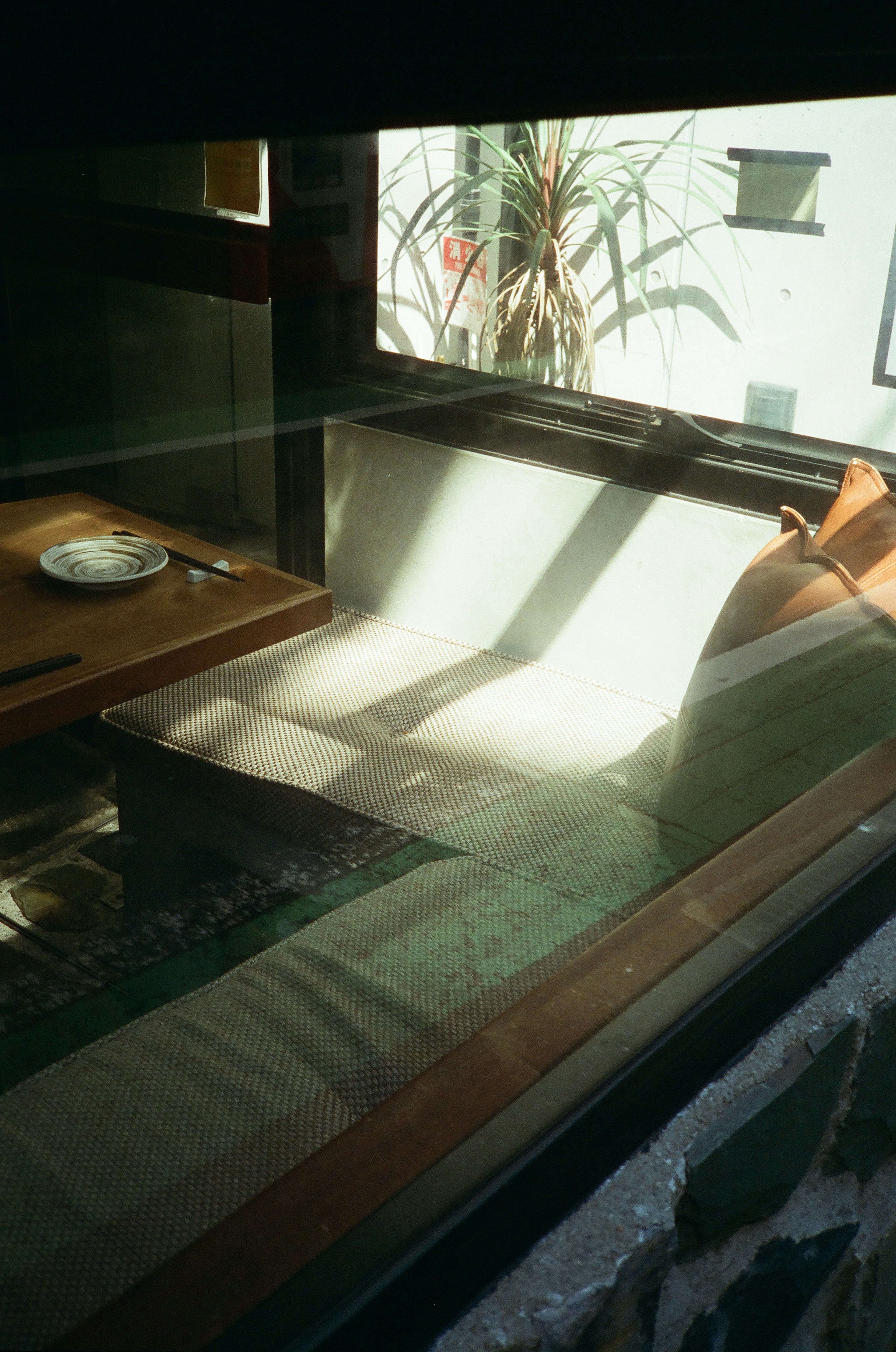 Bright sunlight streaming through a window illuminating a sofa and table